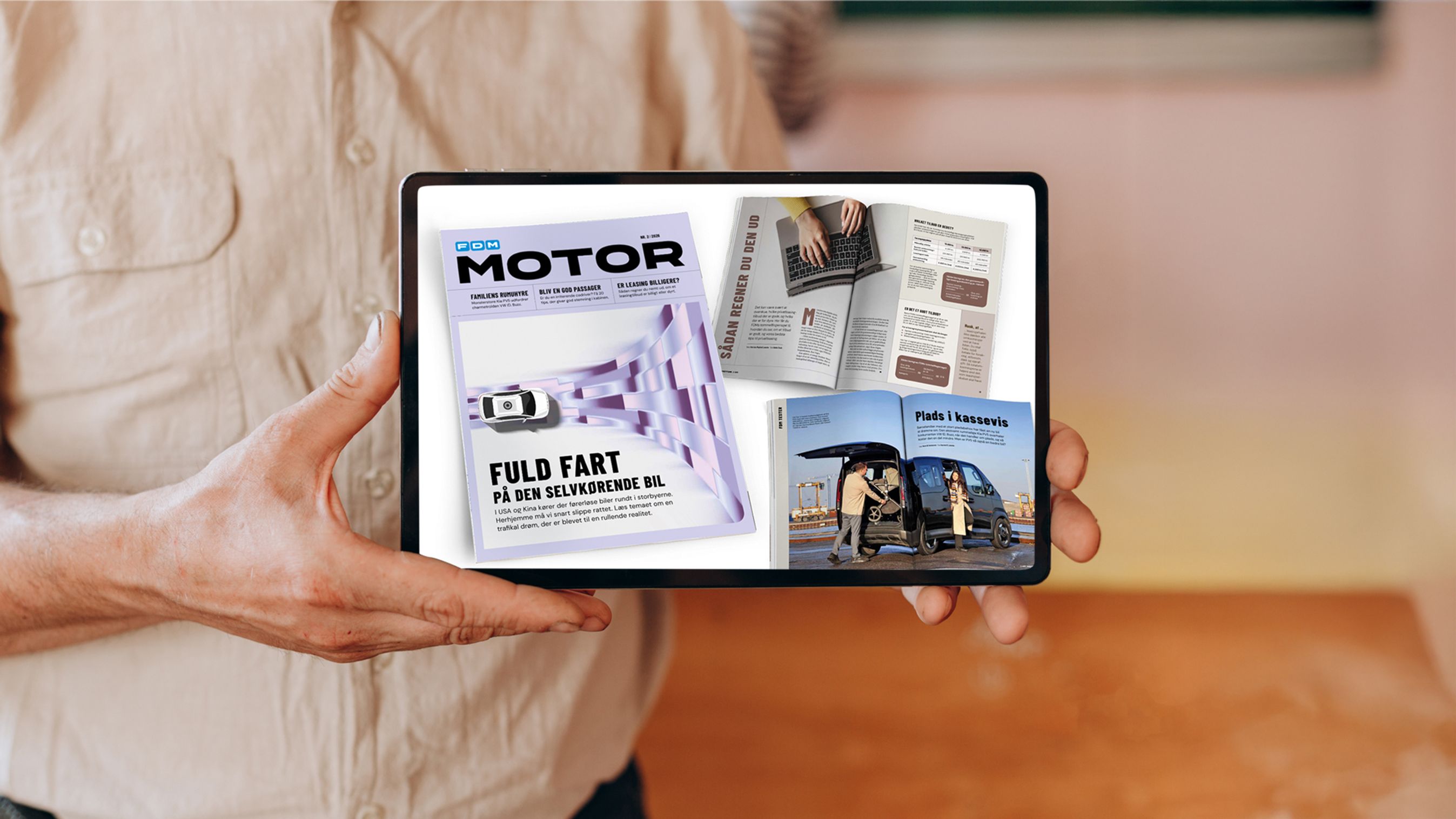 Mand holder iPad med sider fra Motor 2/26