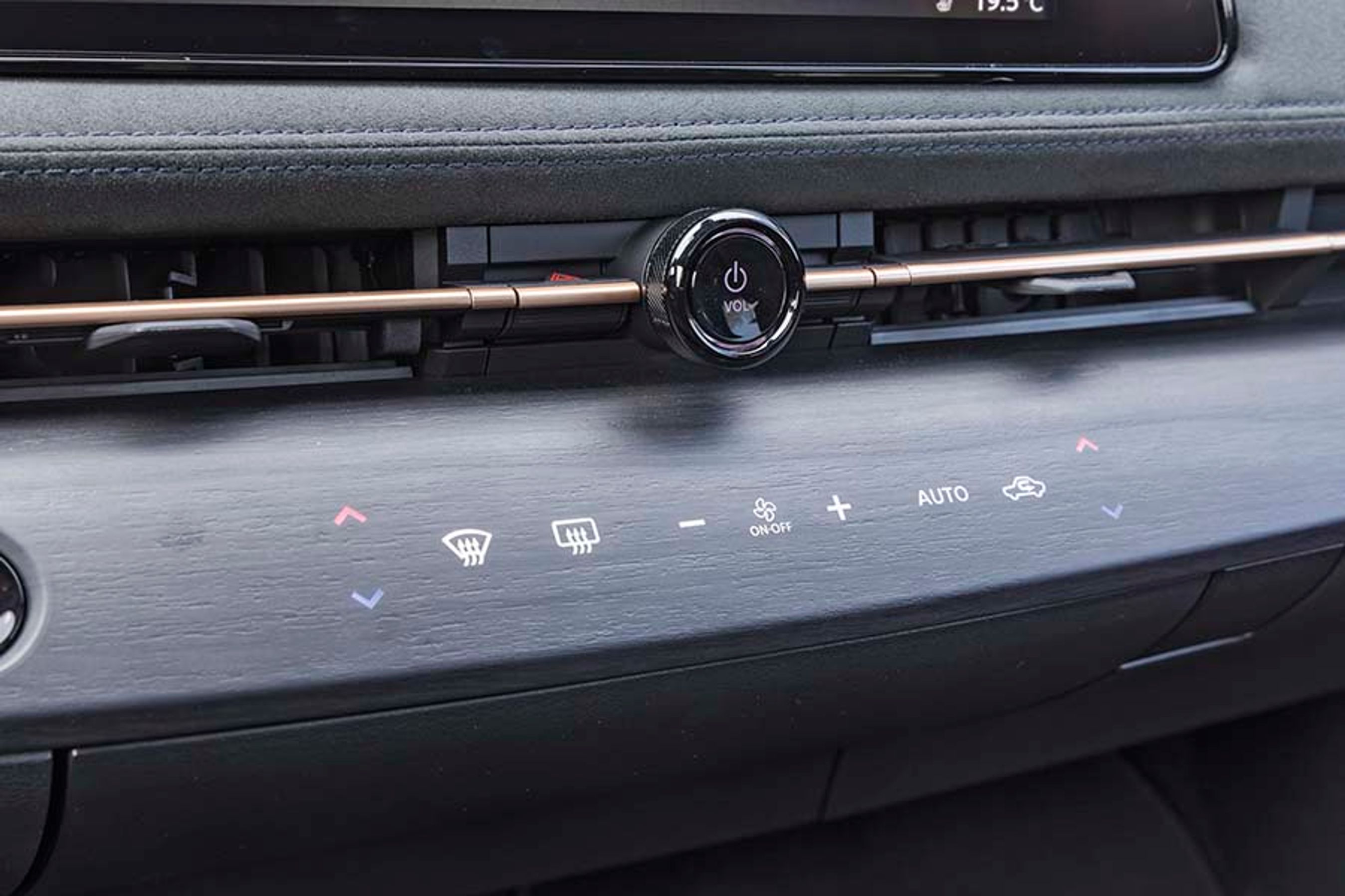 Under skærmen er der indbygget enkelte touch-knapper i det trælignende panel. Det ser smart ud, men man er nødt til at se på knap og finger, da man ikke kan mærke sig frem. Det kan tage lidt af opmærksomheden væk fra vejen.