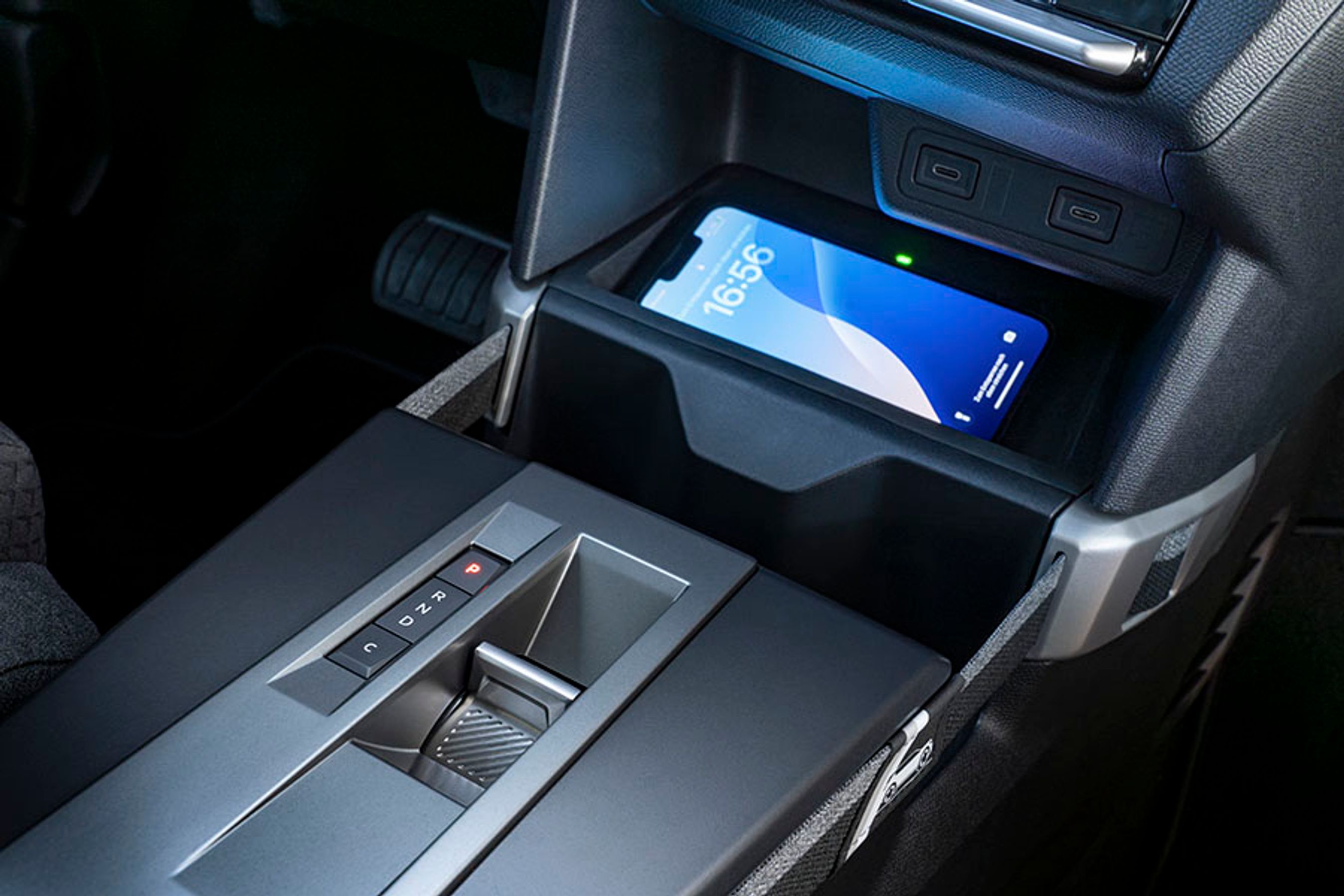 Midterkonsollen rummer plads til en mobil, der kan oplades trådløst, og bag den er den lille gearvælger placeret. I D (Drive) er der en vis motorbremsning, mens man ved tryk på C (Comfort) blot triller, når man slipper speederen.