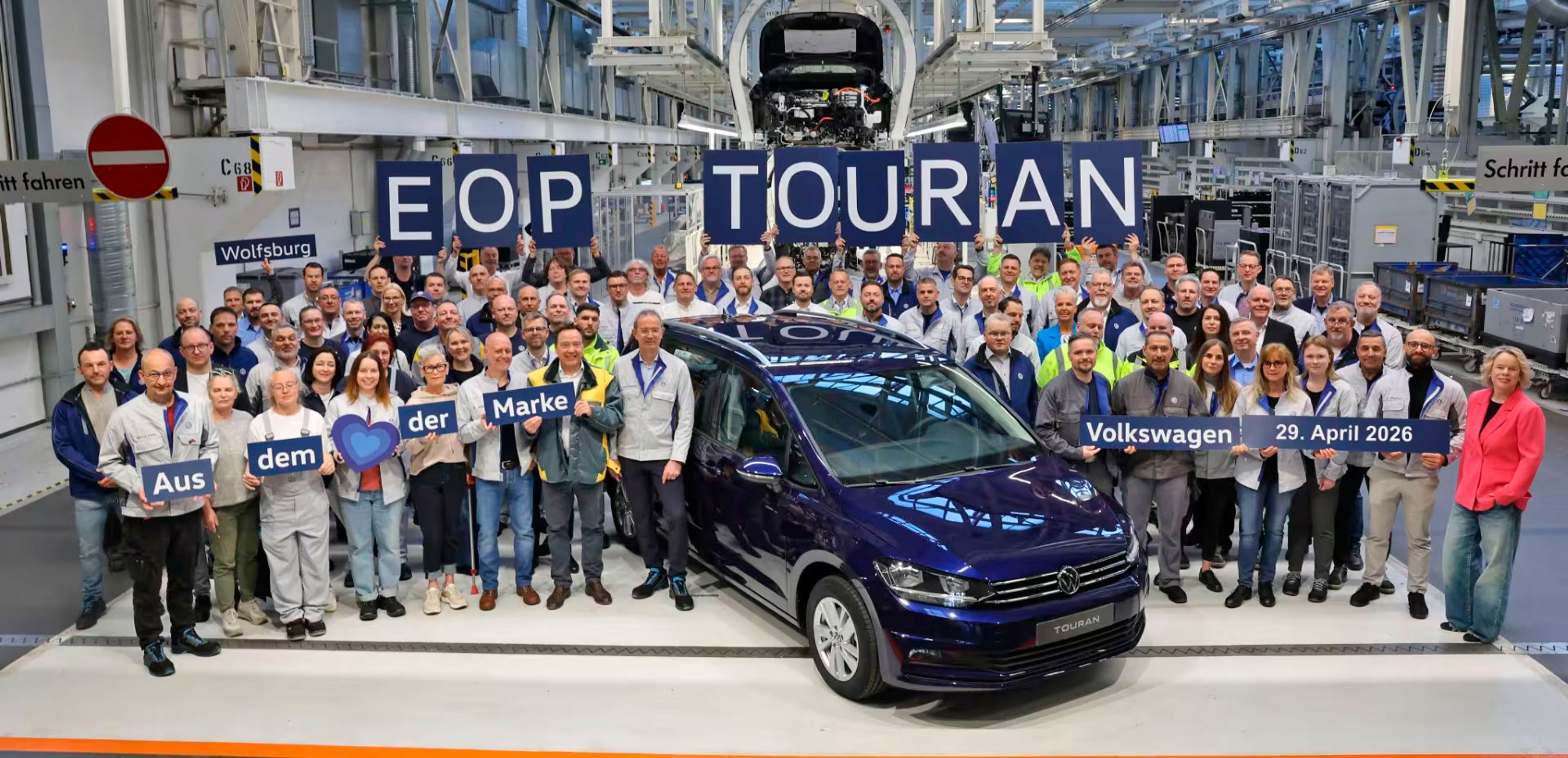 Blå VW Touran med en masse personer rundt om.