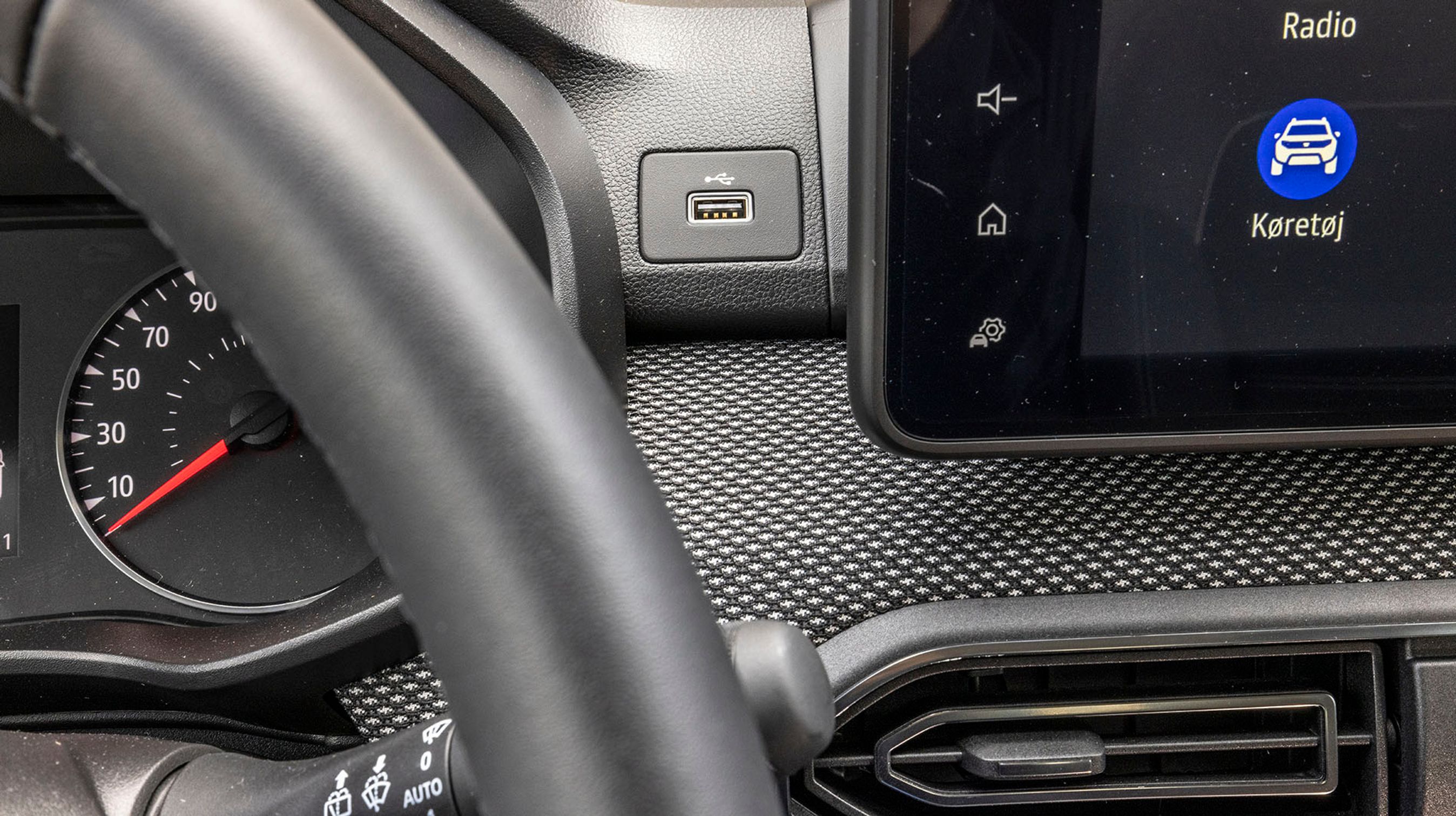 Til venstre for skærmen er der et usb-stik til mobiltelefonen. Man kan få en særlig holder, der kan holde mobilen fast under kørslen, så den kan bruges på lovlig vis.