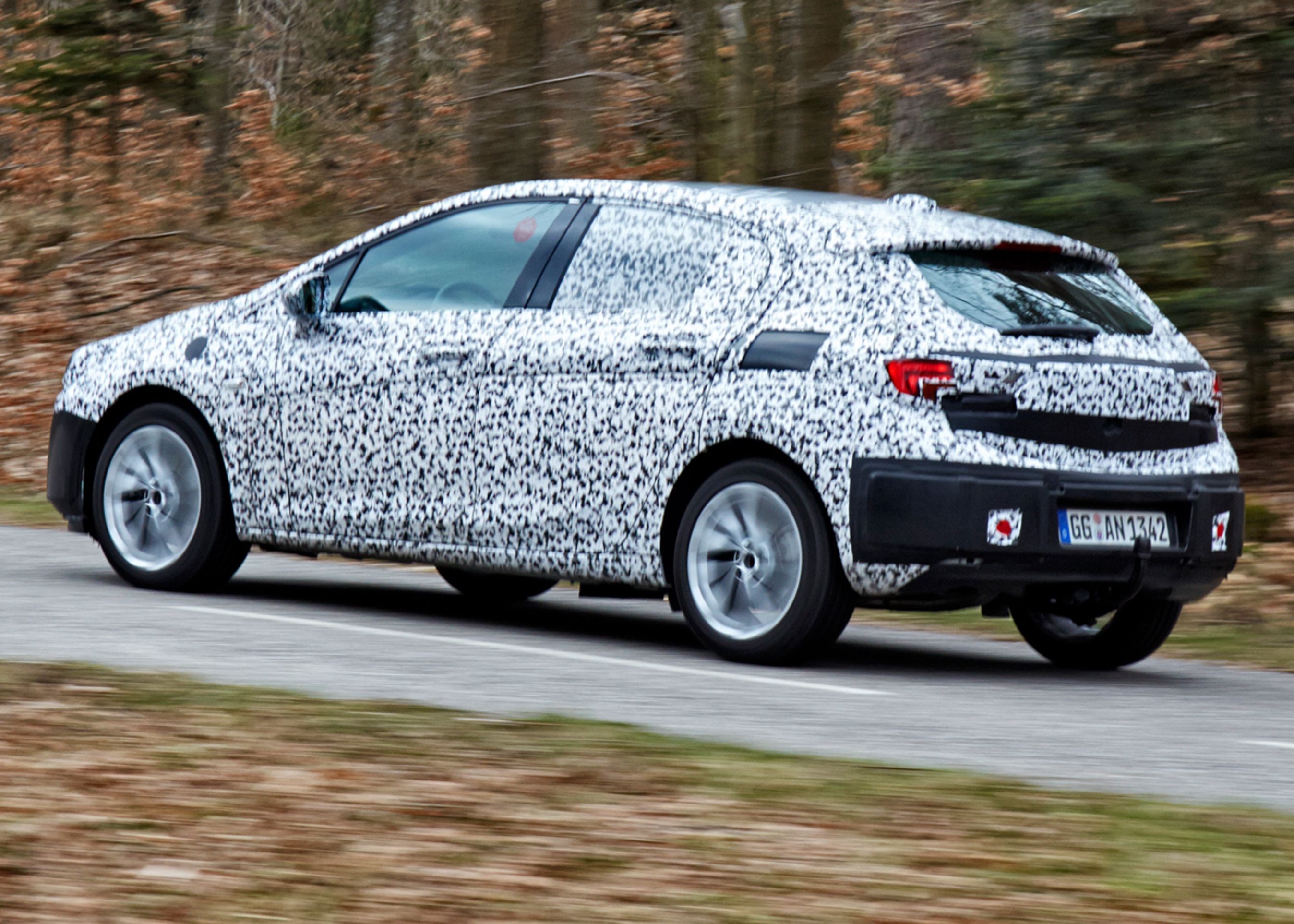 Den nye Opel Astra dukker først op som denne femdørs og et år senere som stationcar. Tredørs droppes. Endnu er designet skjult af kamuflage-folie, men linjerne kan dog anes. Fotos: Opel