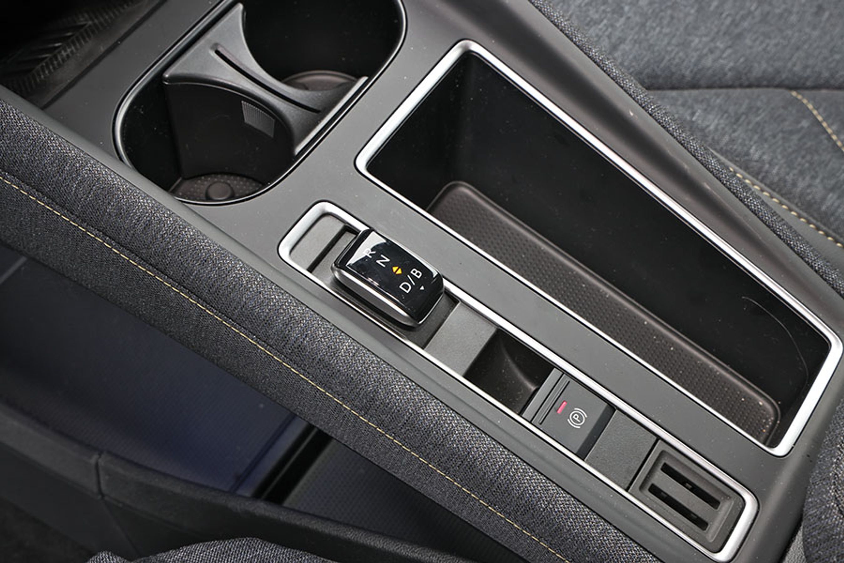 Mellem forsæderne er gearvælgeren placeret, og den er let at betjene. Der er gode fralægningspladser, men kopholderne fortil er små og kan ikke rumme en drikkedunk.