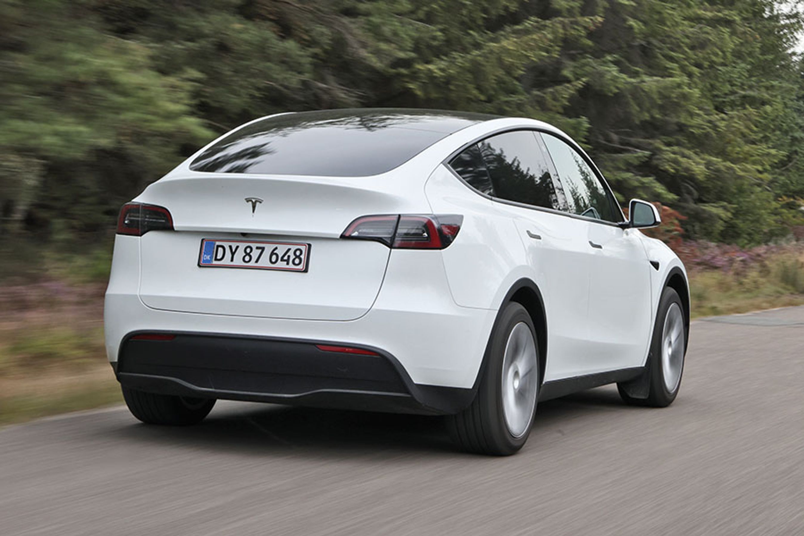 Tesla Model Y set bagfra, mens den kører på en vej