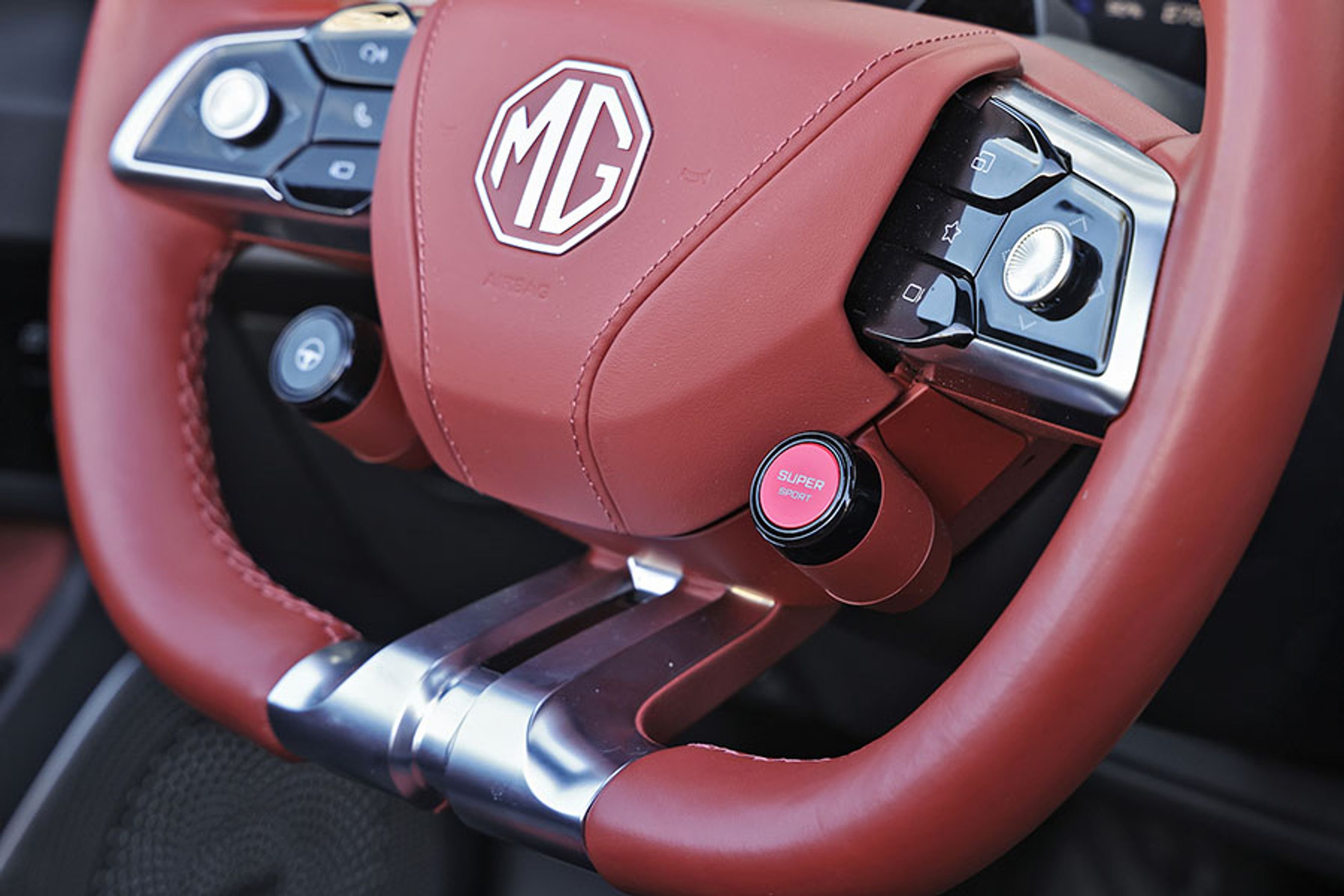 Den røde knap aktiverer den kraftige acceleration i MG Cyberster, så du kan få en 0-100 km/t-oplevelse på 3,2 sekunder. Det er helt vildt.