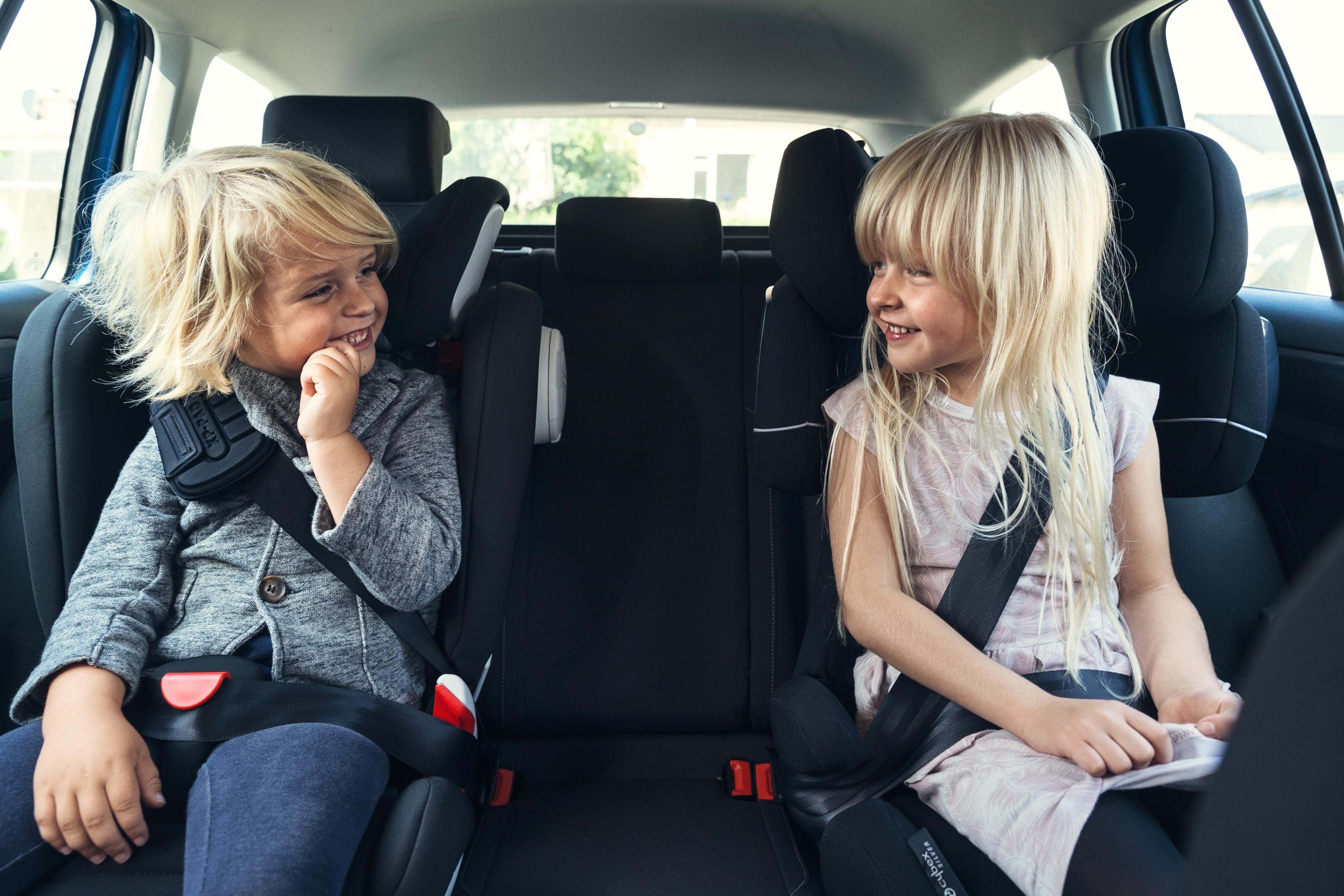 børn der sidder i autostol i bil
