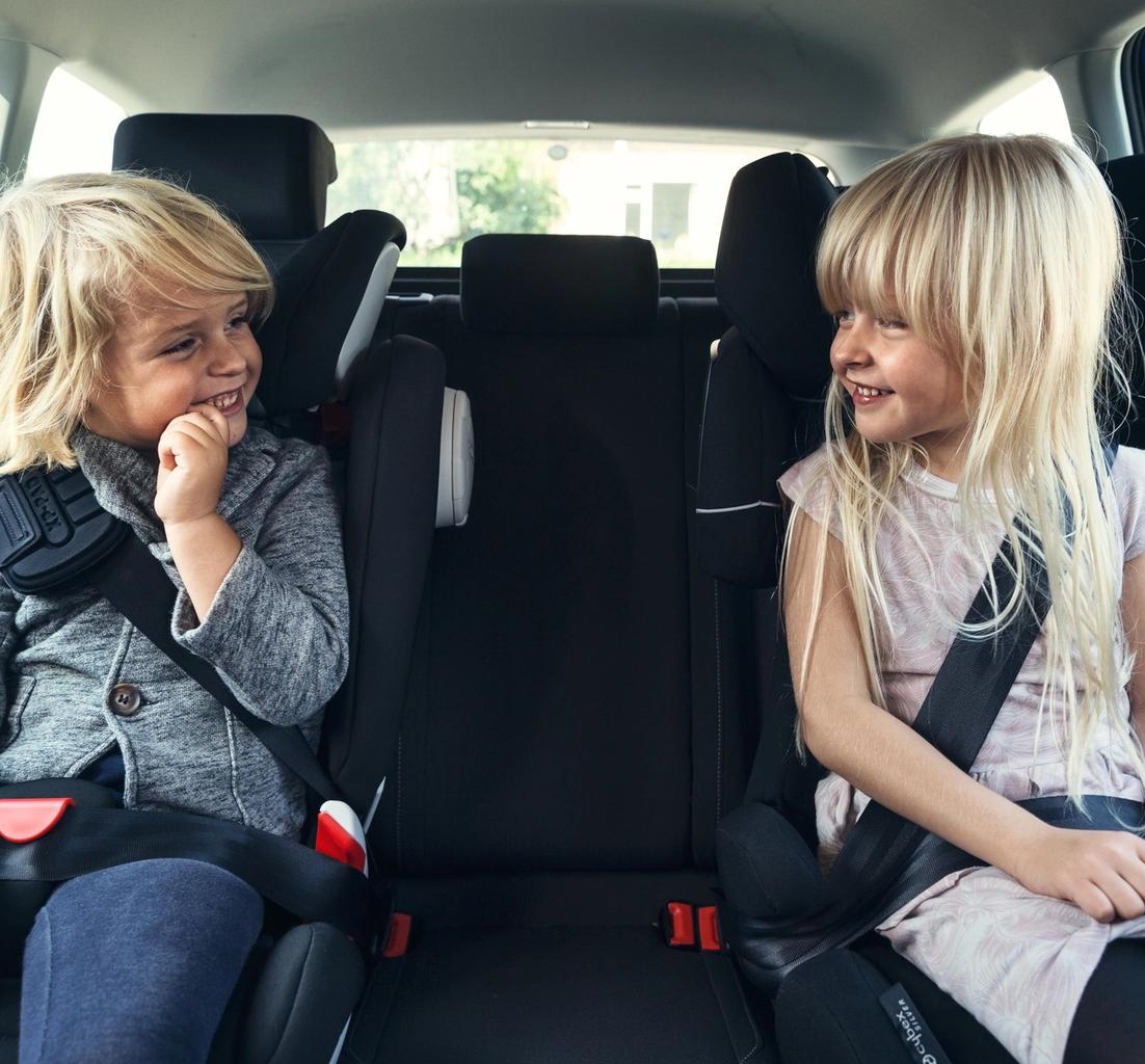 børn der sidder i autostol i bil