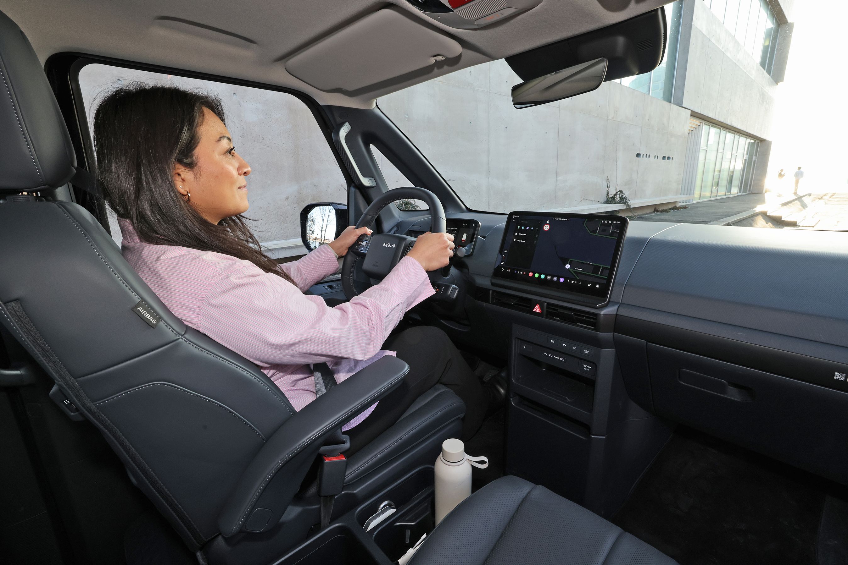 Person sidder bag rattet i en Kia PV5