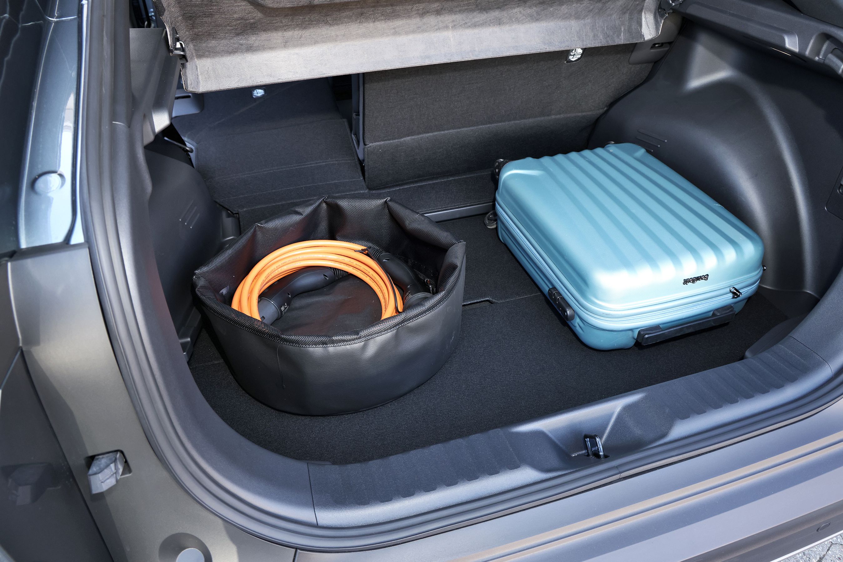 Bagagerum med kuffert og ladekabel i en Toyota C-HR+