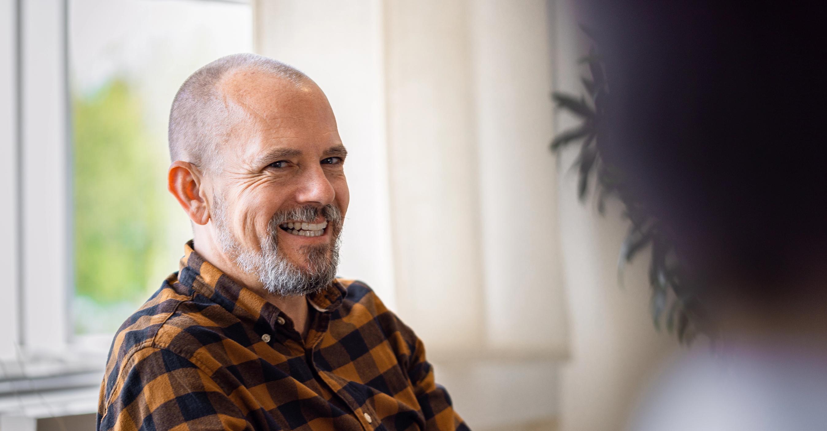 En person i et møde smiler til en anden person