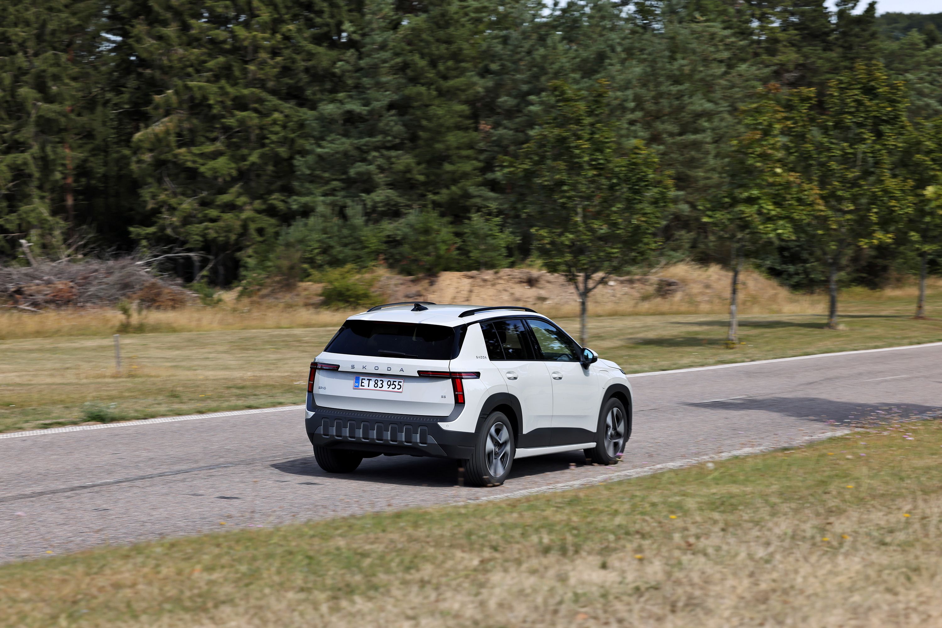Skoda Epiq 55 Selection Launch Edition fra 2026 set bagfra på landevej med grønne træer i baggrunden. 