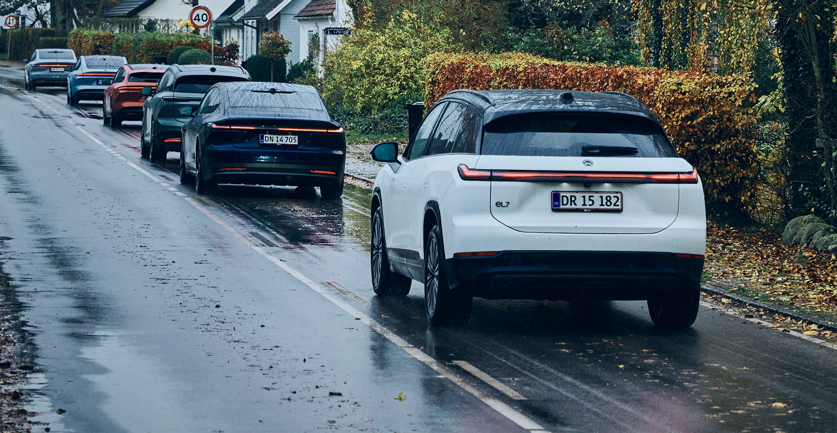 En stribe Nio-biler kørende set bagfra.