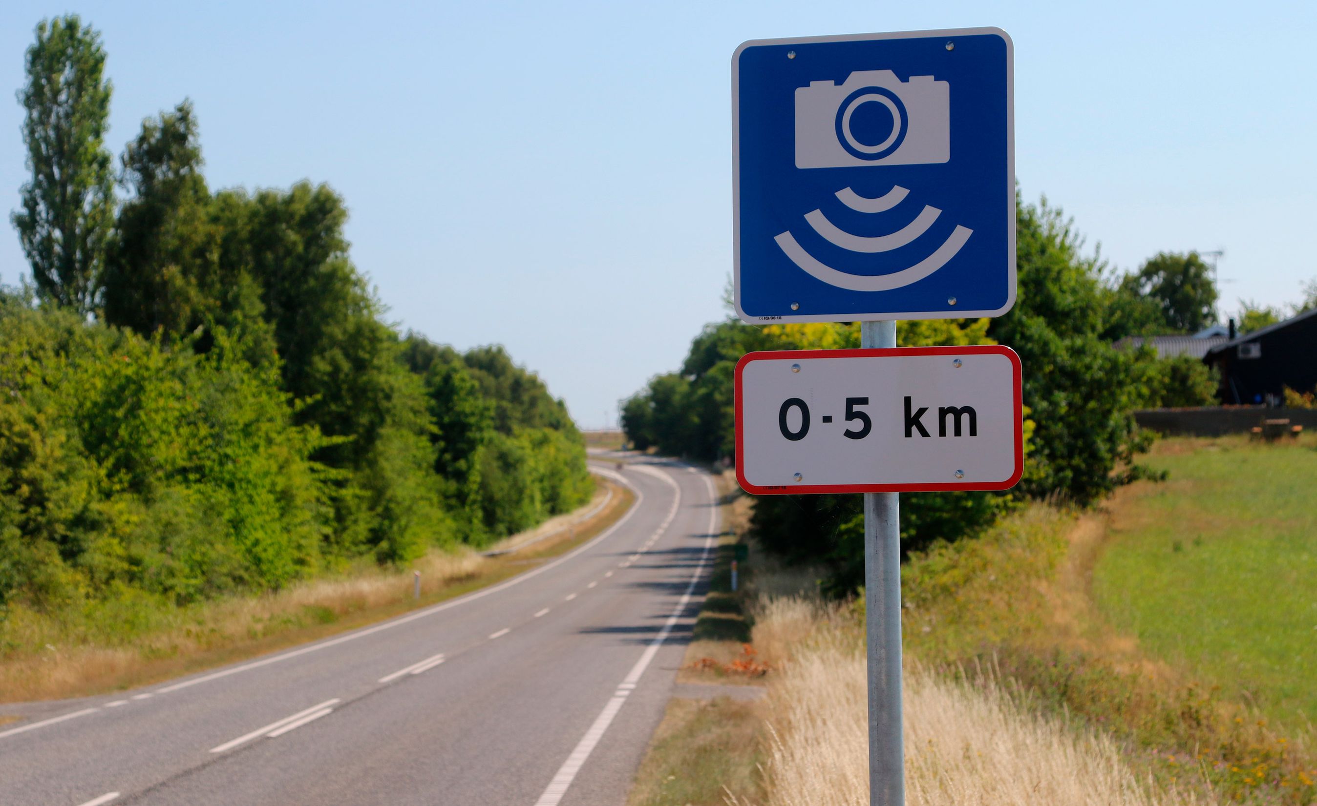 Blåt skilt advarer om høj risiko for fartkontrol.