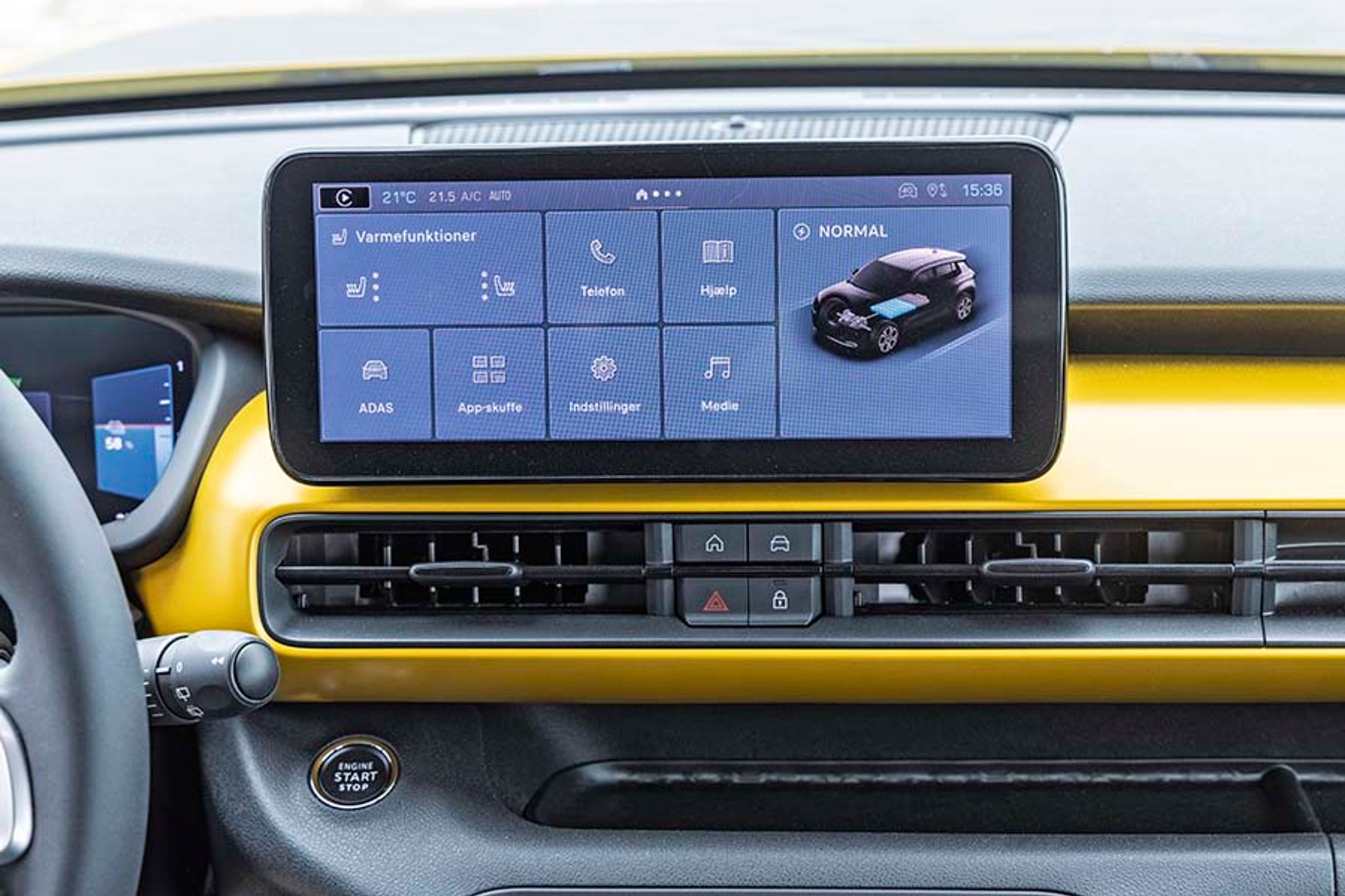 Skærmen i midten har danske menuer og er enkel i sin menustruktur. Lige under skærmen er der en hjemknap, som straks bringer én tilbage til udgangspunktet. Øverst til venstre er der en knap til Apple CarPlay eller Android Auto.