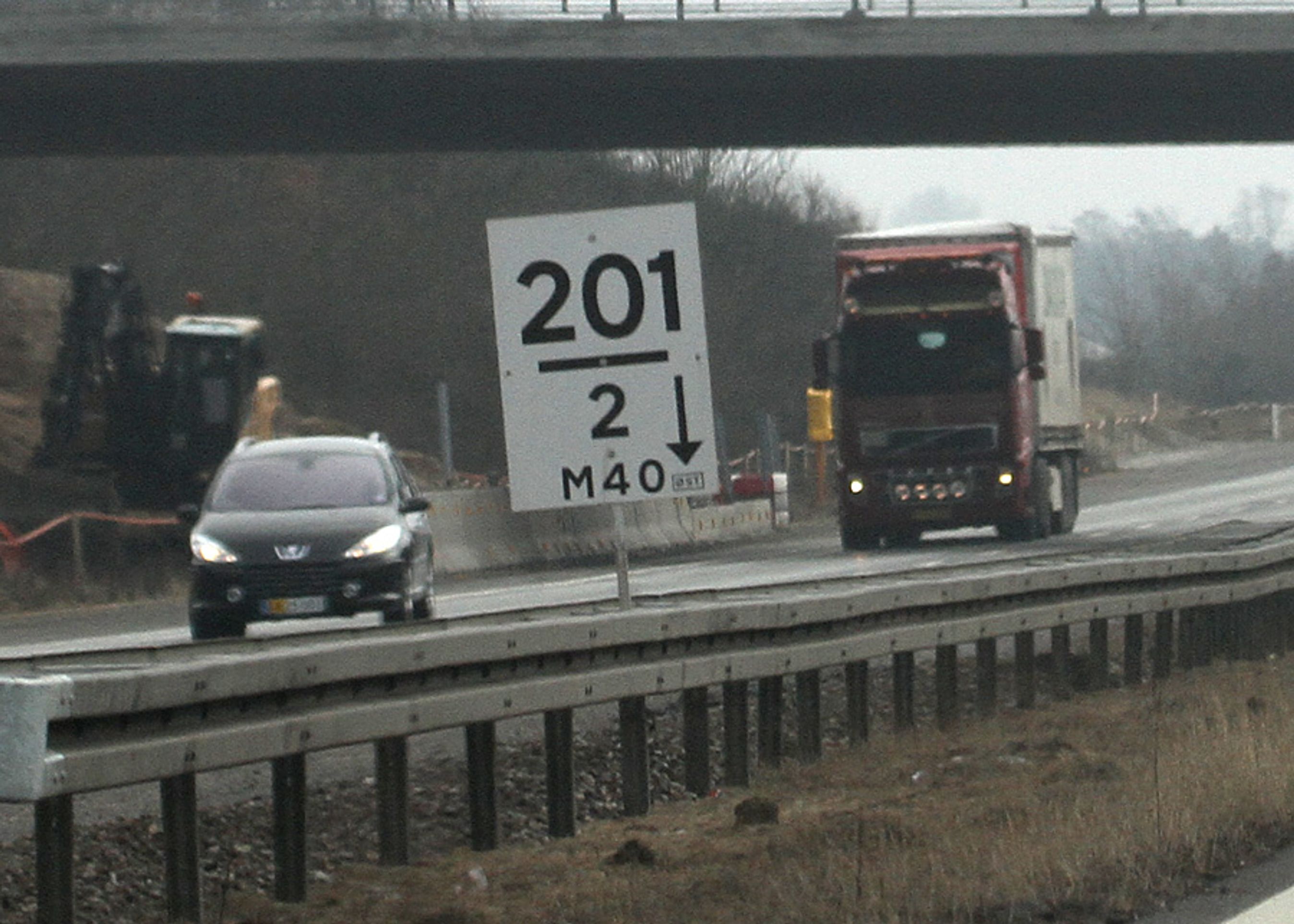 De særlige km-tavler ved store vejarbejder: 201 betyder 201 km (fra et givet sted), 2-tallet under angiver 2 hundrede meter, altså samlet km 201,2. Med småt står der, at det er i østgående retning. M40 er den administrative betegnelse for vejen.