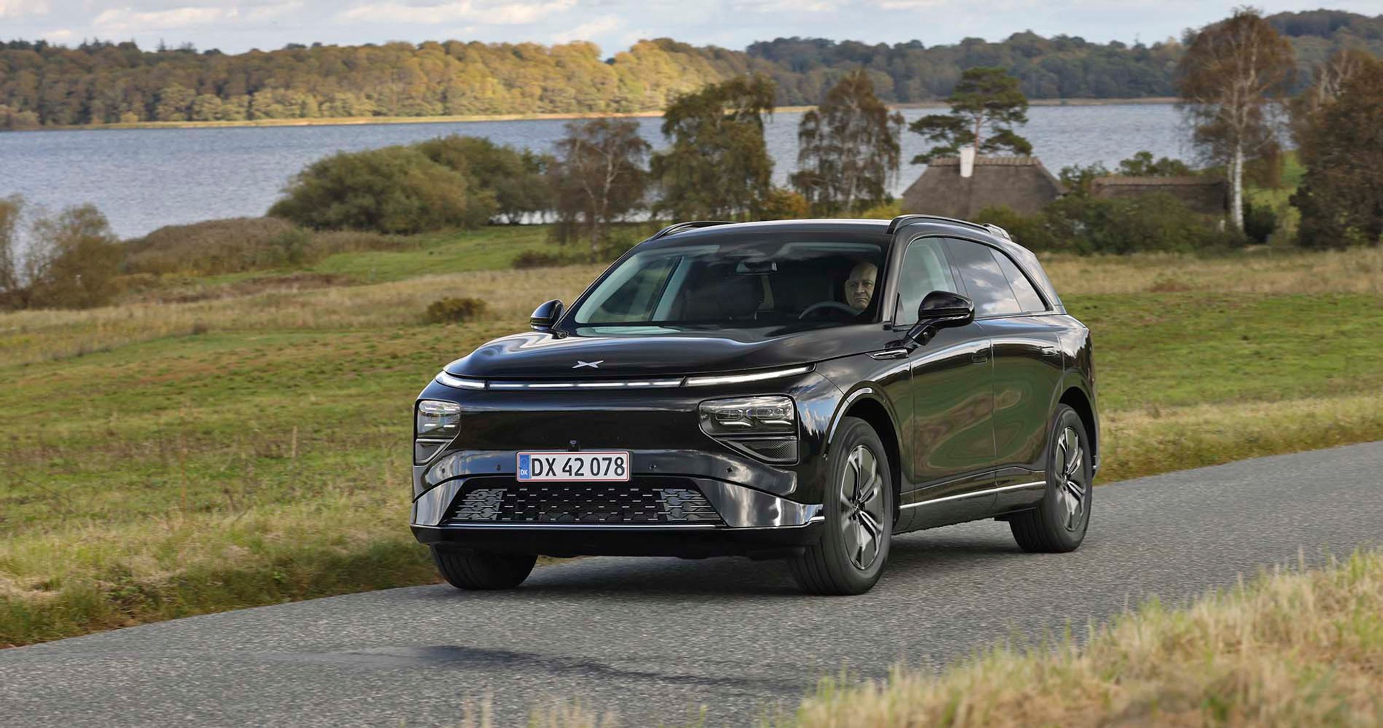 Elbilen Xpeng G9 kører på landevej med sø i baggrunden