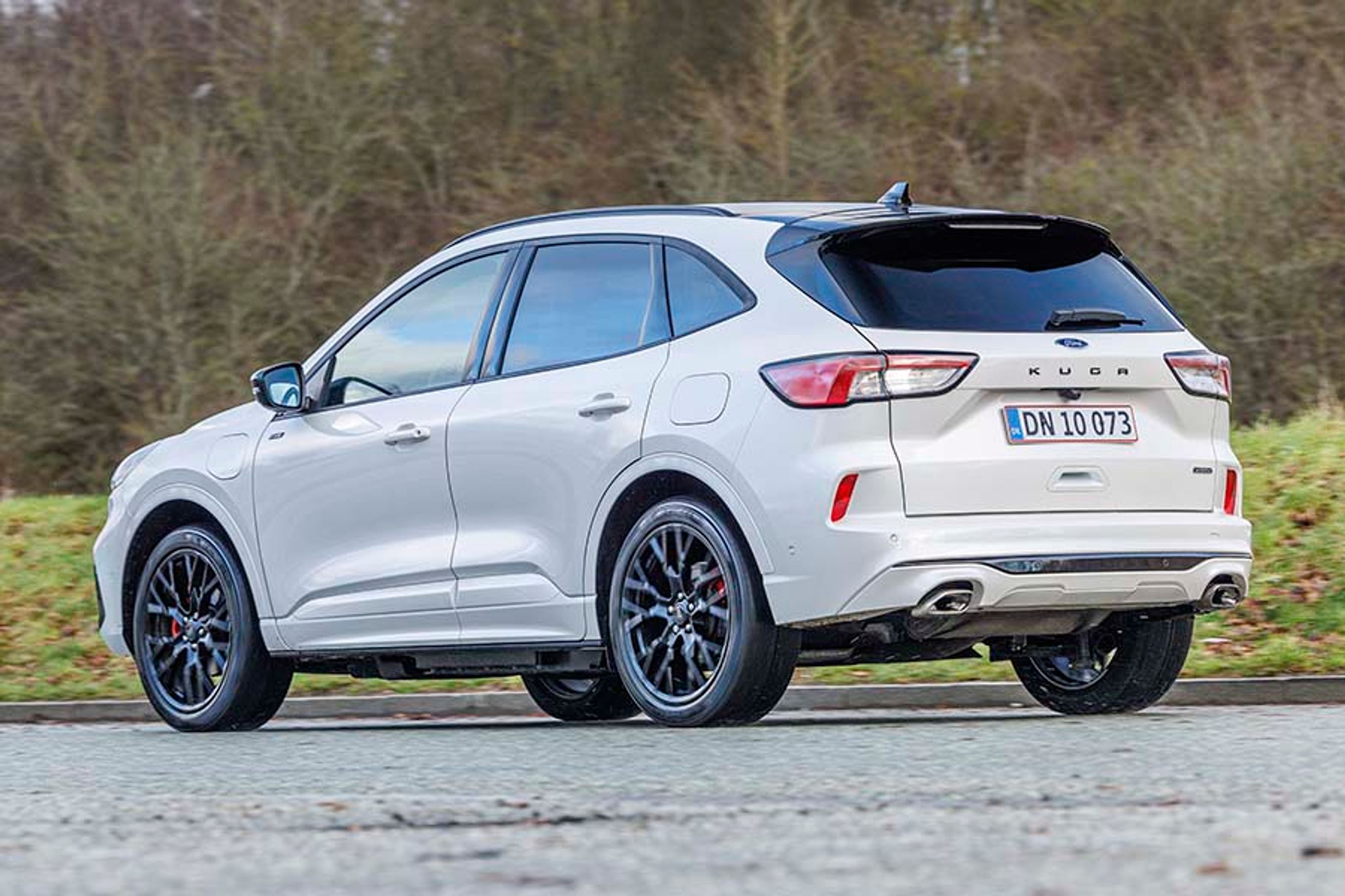 Ford Kuga holder på en landevej med træer i baggrunden
