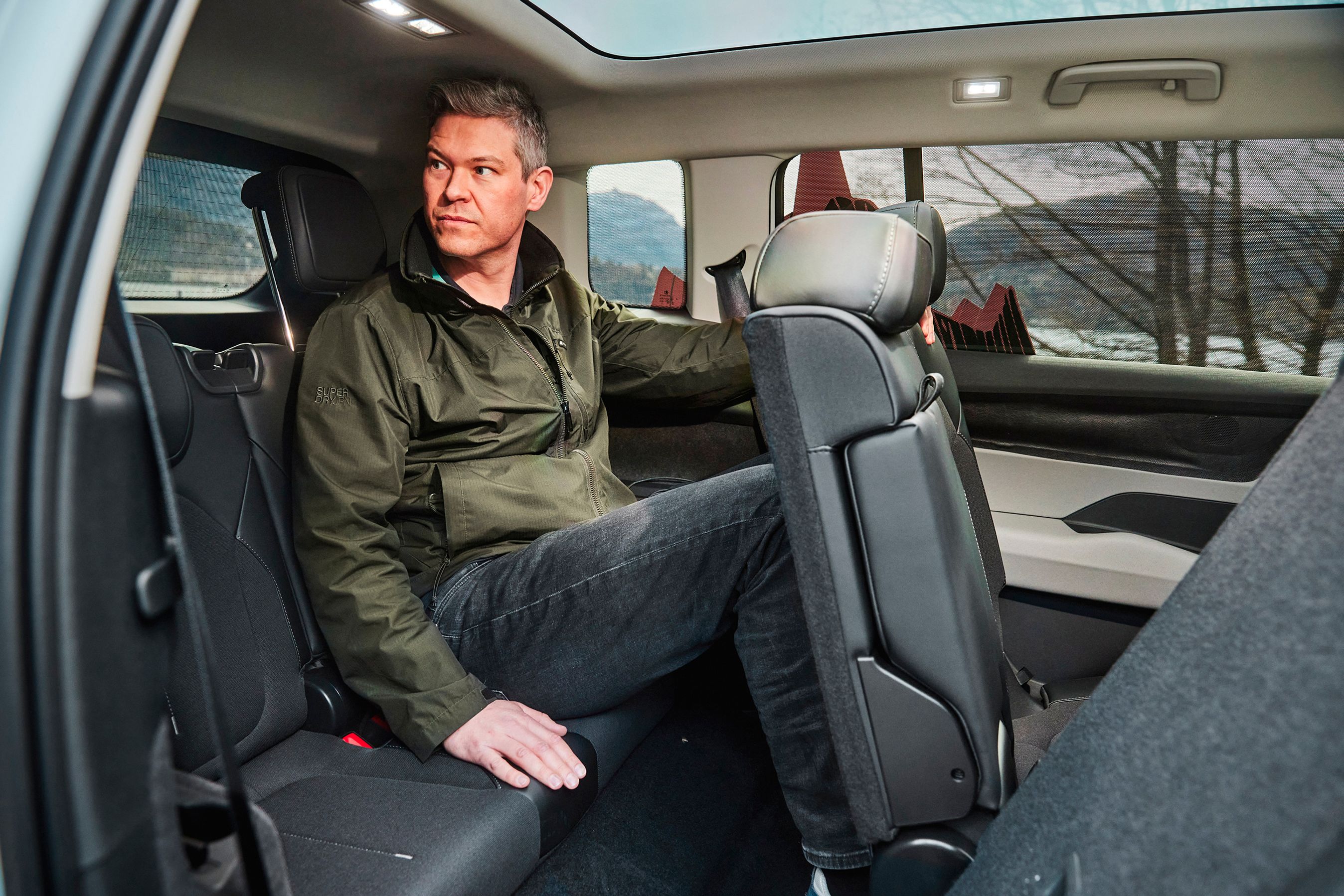 Mand sidder på bagsæde.