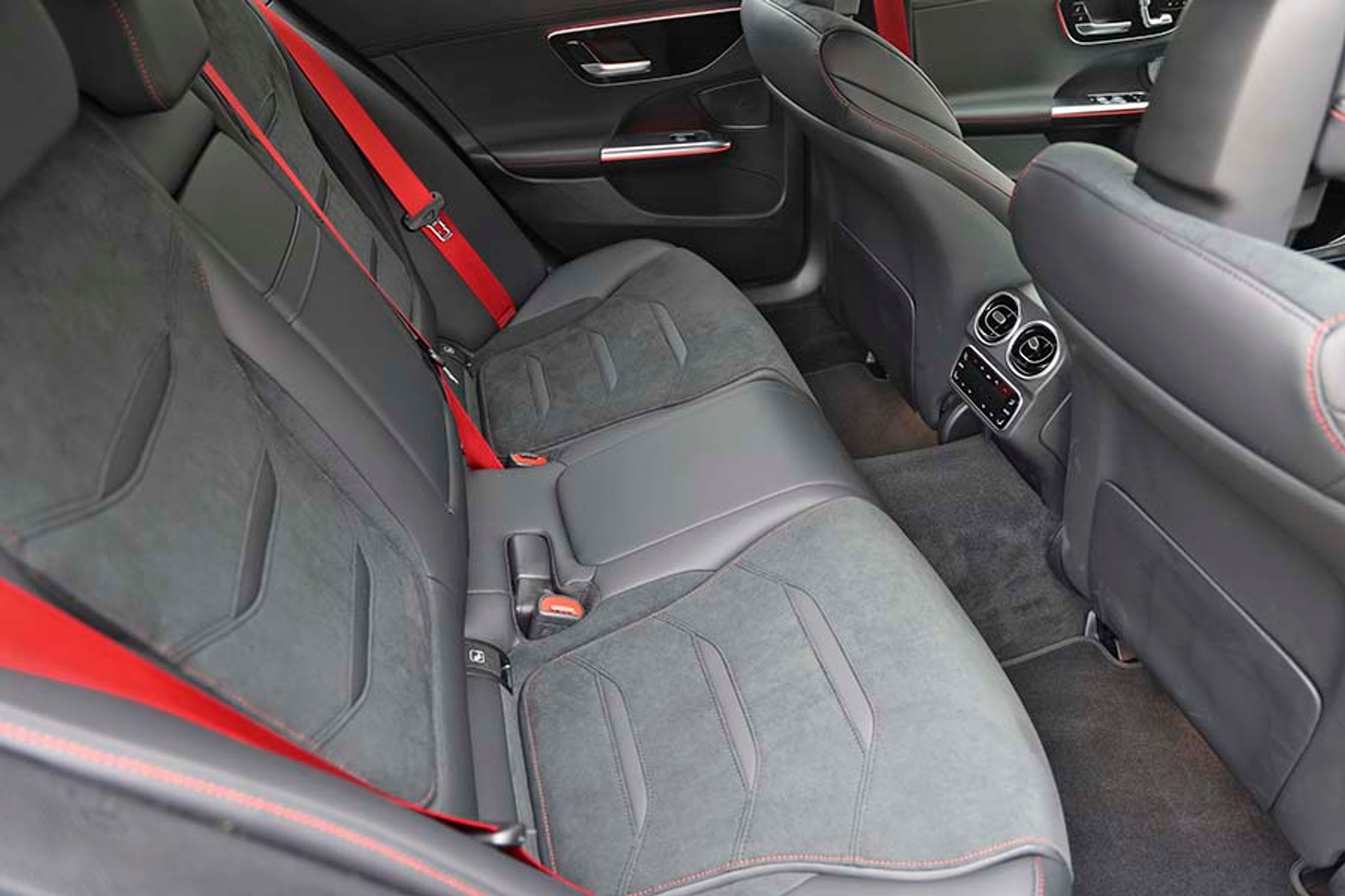 Bagsædet har naturligvis også røde sikkerhedsseler. Der er fine friskluftdyser mellem forsæderne, hvor også en ret stor kardantunnel generer midterpladsen bag.