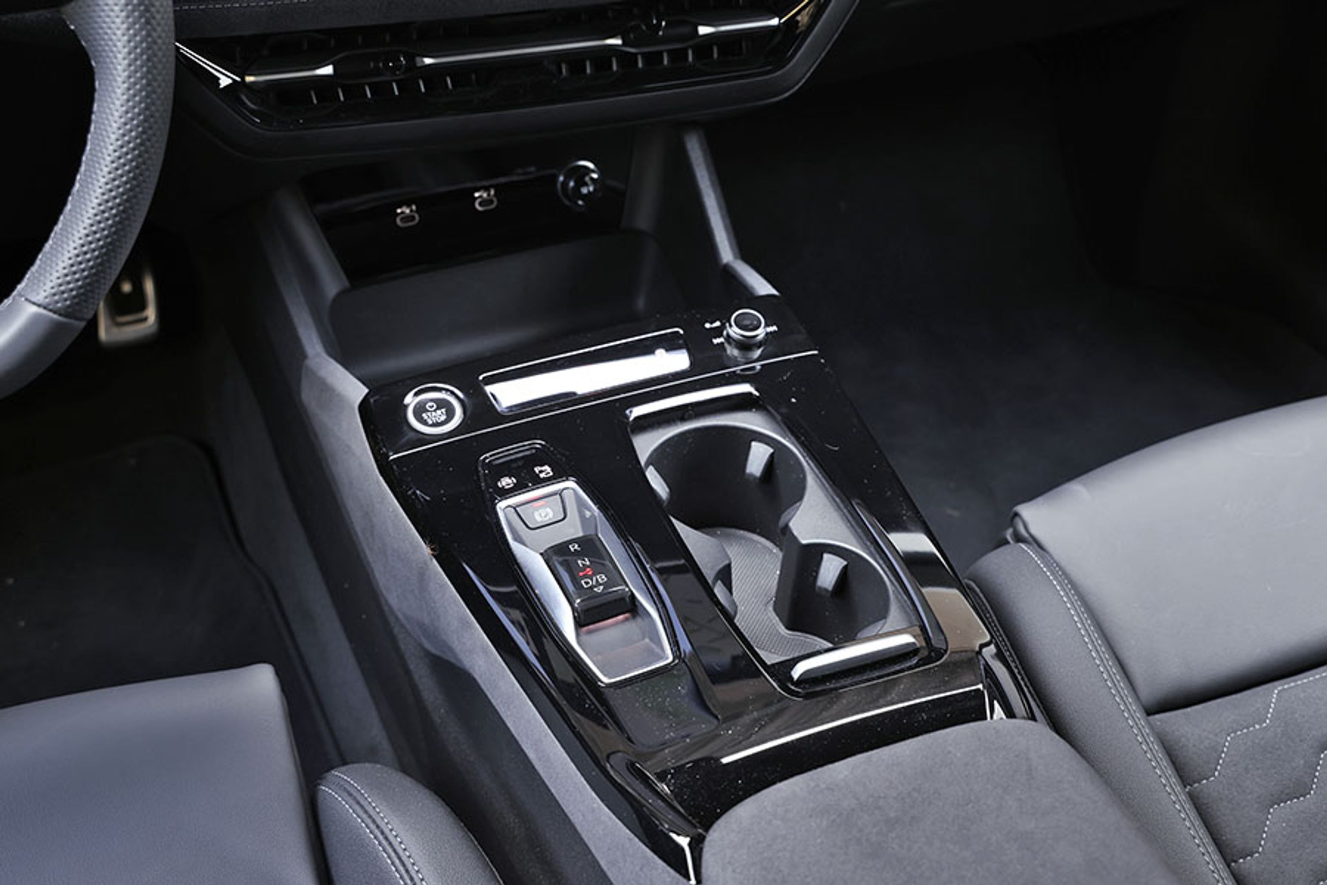 Gearvælgeren er placeret som en lille knap mellem forsæderne. Den skubbes frem eller tilbage afhængig af køreretningen. Bemærk den fine, runde knap til styring af lydniveauet.