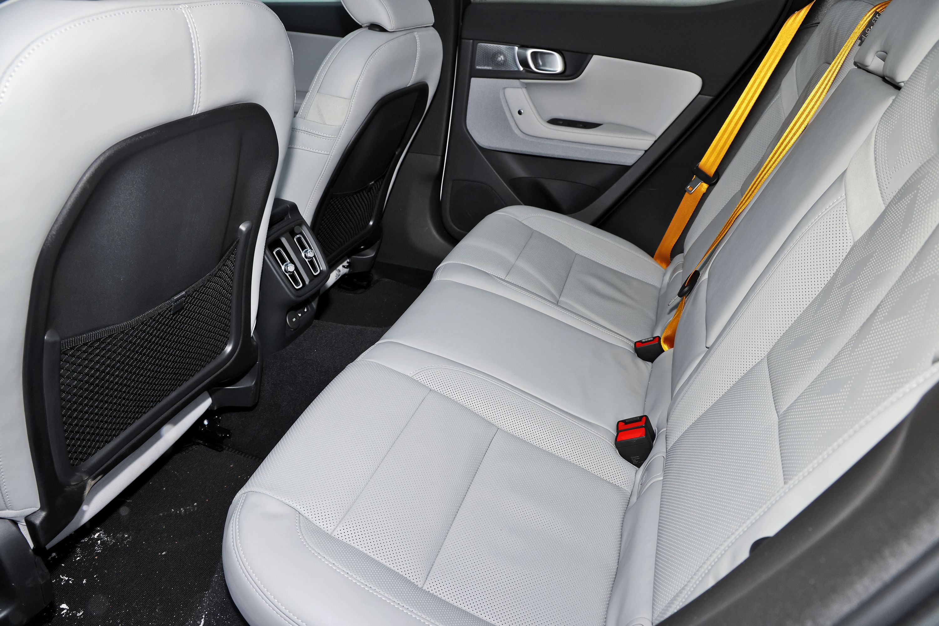 Bagsædet på Polestar 2 AWD Performance. Du kan se friskluftdysser og gule sikkerhedsseler. 