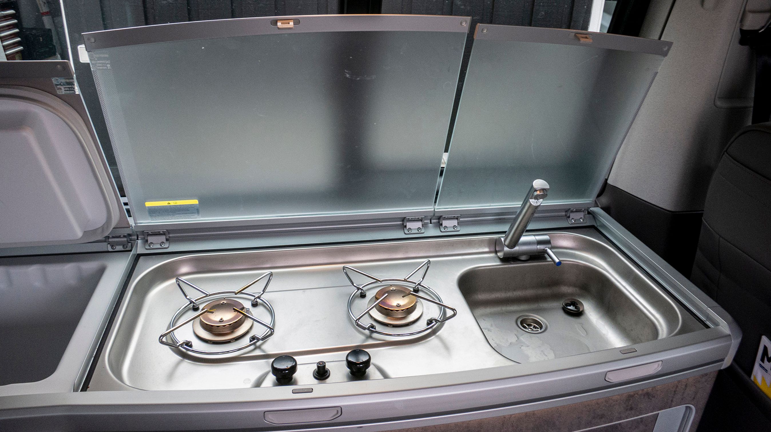 Der er både campingblus, vask og køleboks i køkkensektionen langs vinduerne bag førersædet.