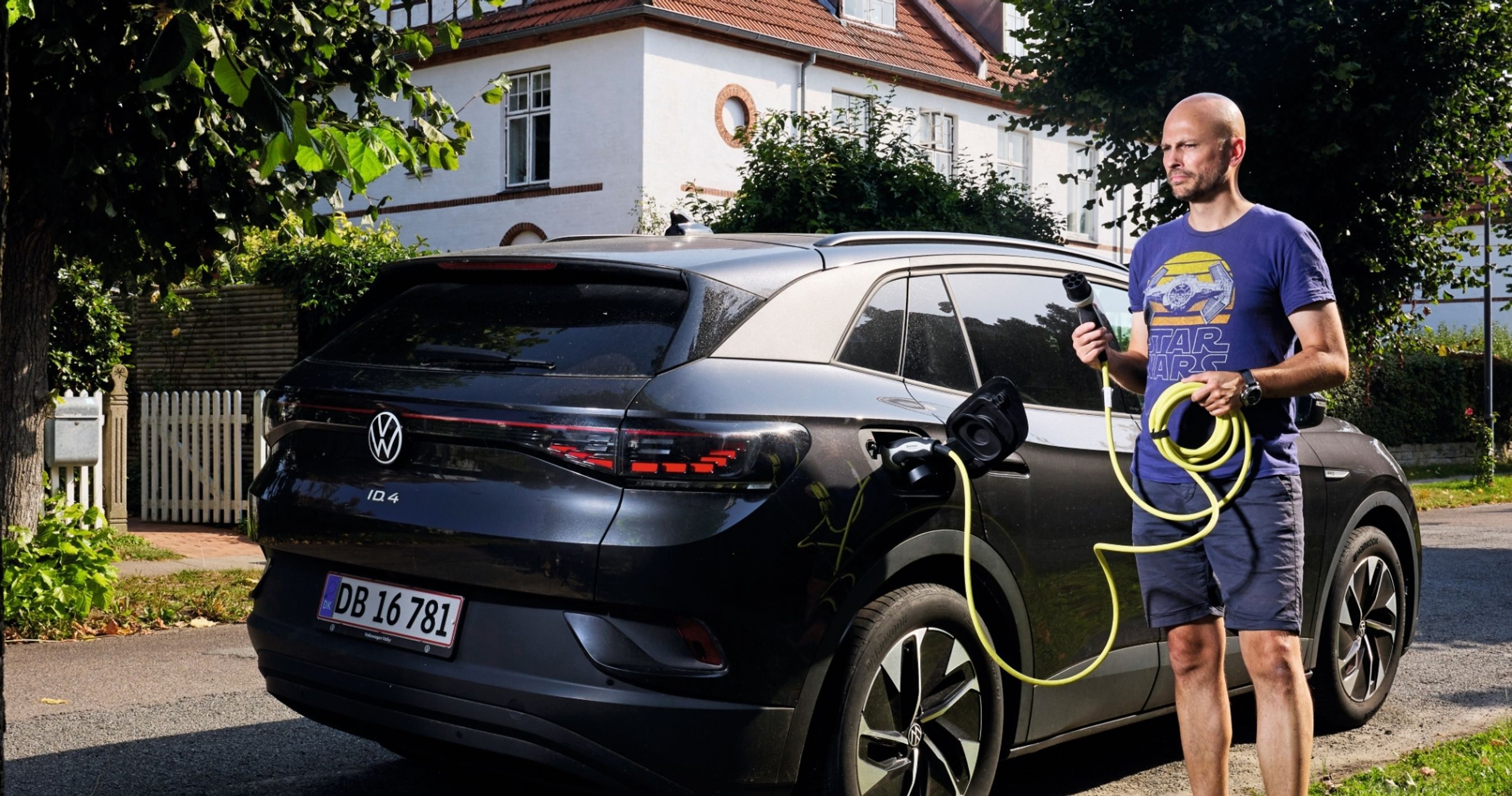 Mand der står ved elbil