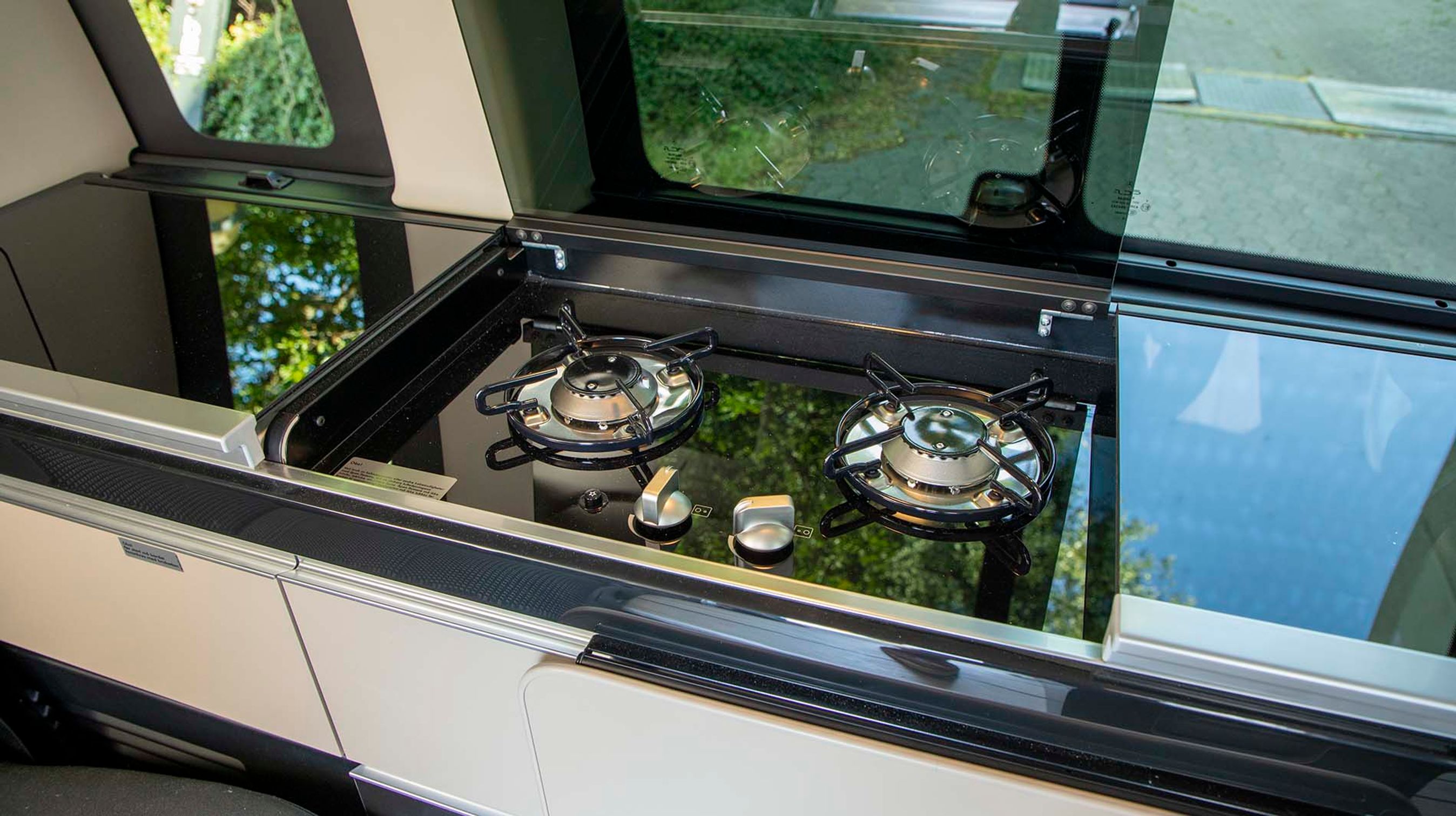 Køkkensektionen indbefatter bl.a. to gasblus og en vask til højre for dem. Til venstre er der et rummeligt køleskab.