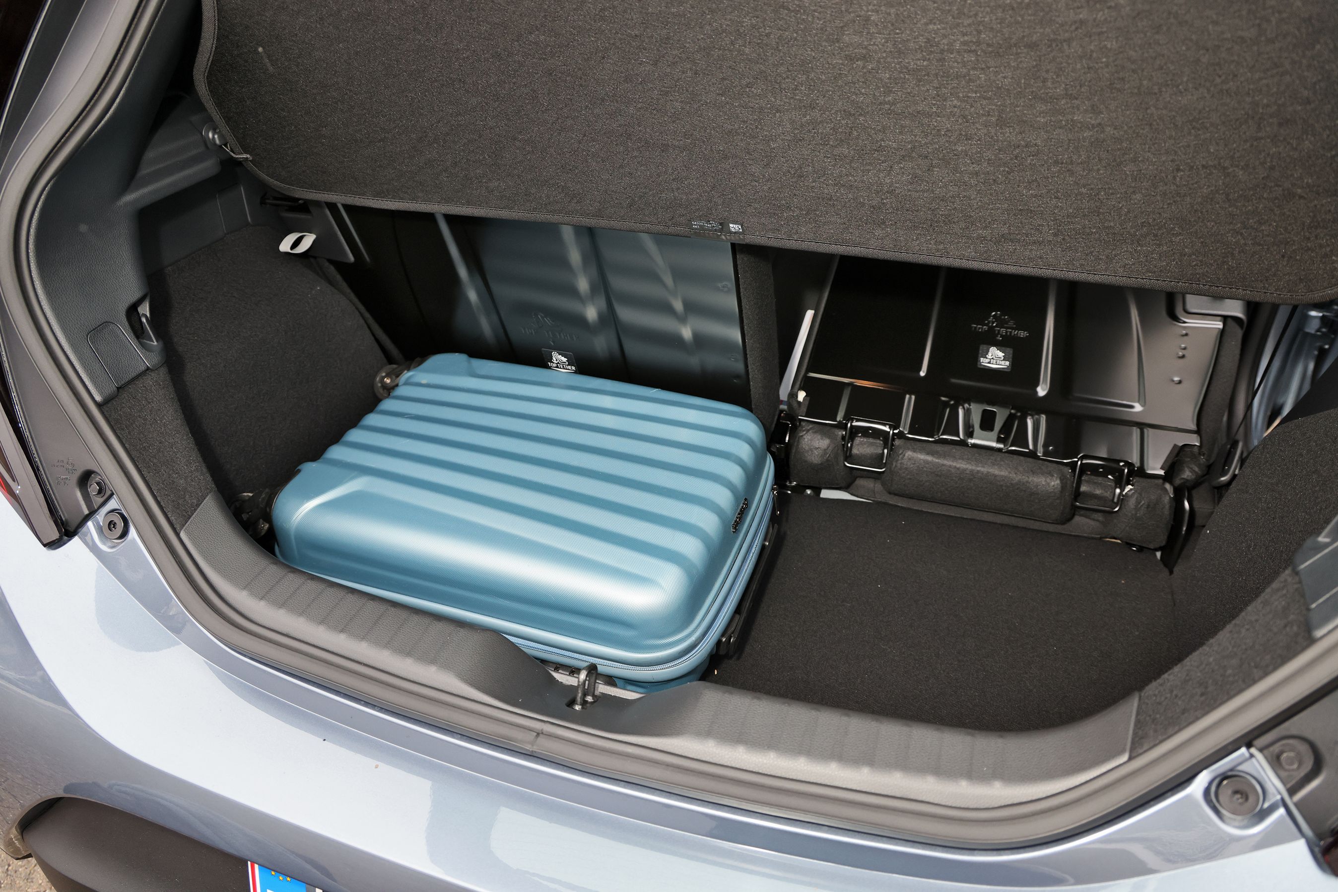 Bagagerum med blå kuffert i en Toyota Aygo X