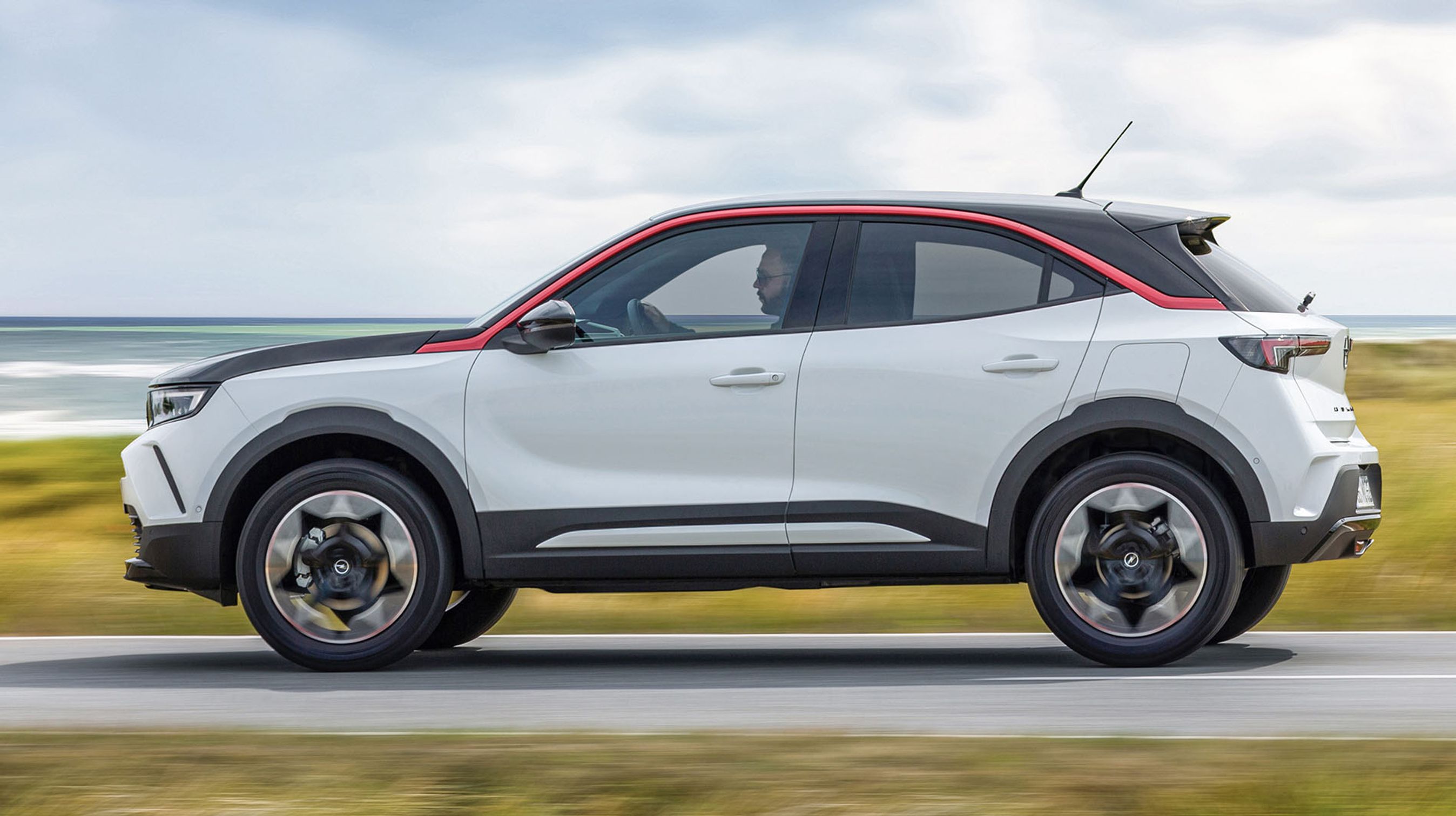 Den nye Mokka fås i flerfarvet lakering og kan på den måde se ganske moderne ud. Den røde, buede liste over dørene er typisk for Opel og giver en lille hilsen til bl.a. den udgåede Opel Adam.