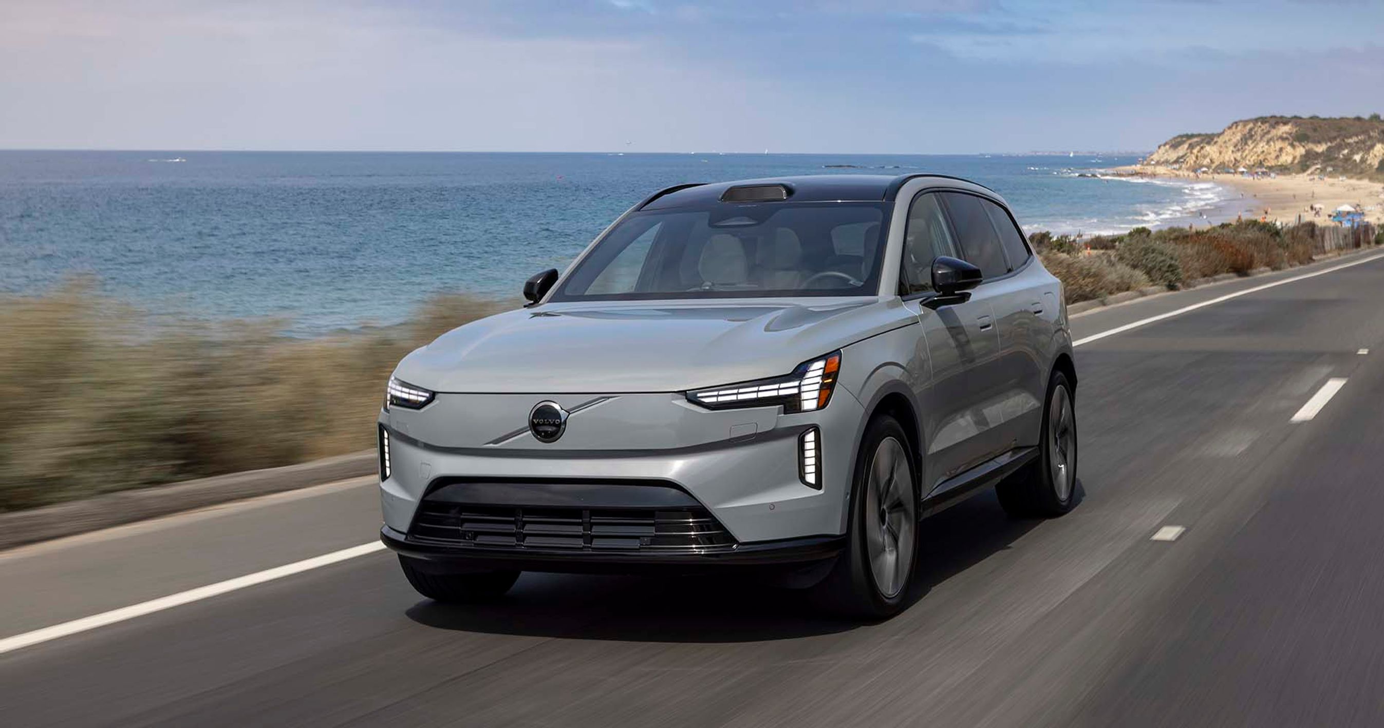 Grå Volvo EX90 kører på vej langs havet