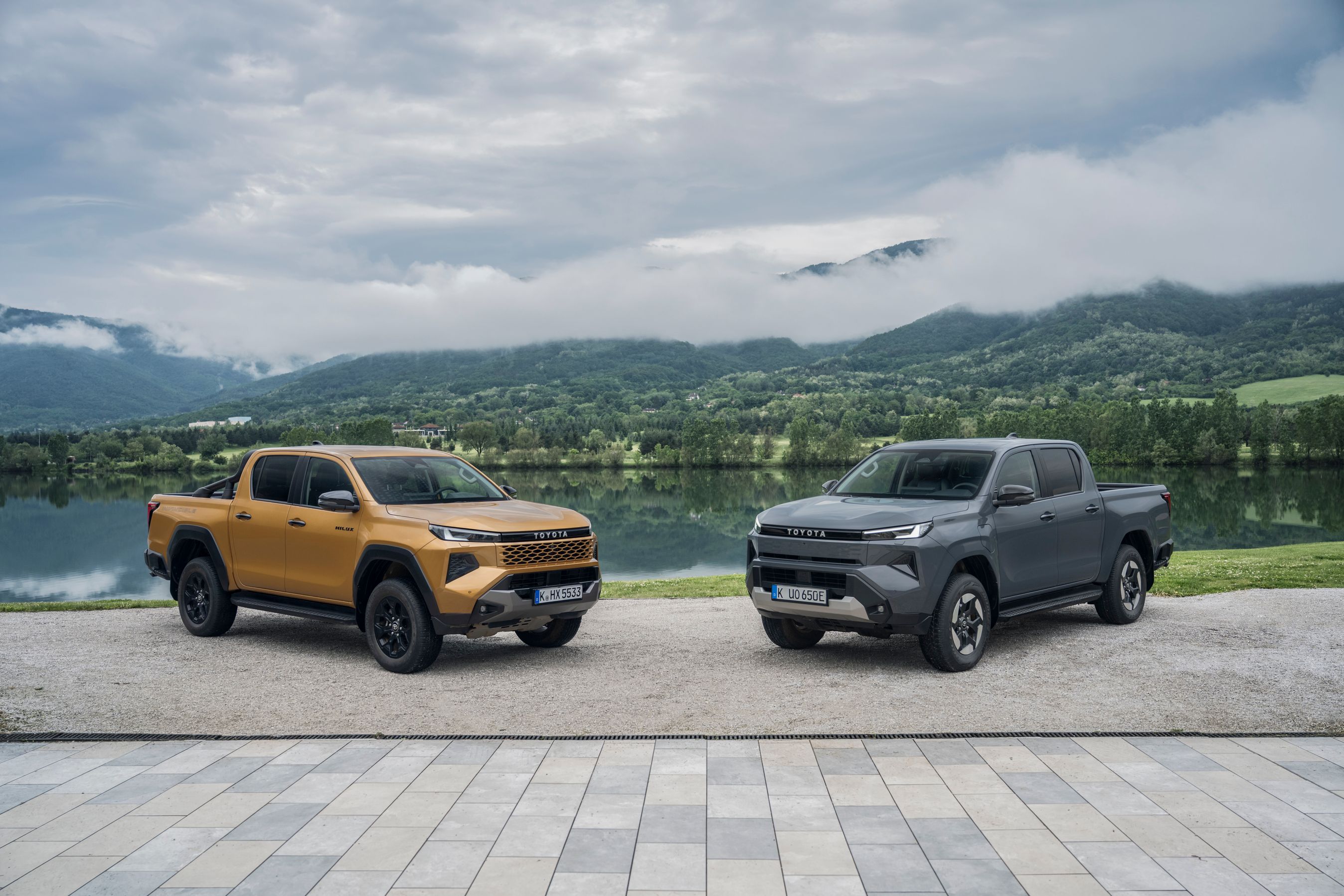 To Toyota Hilux parkeret med udsigt til sø og bjerge