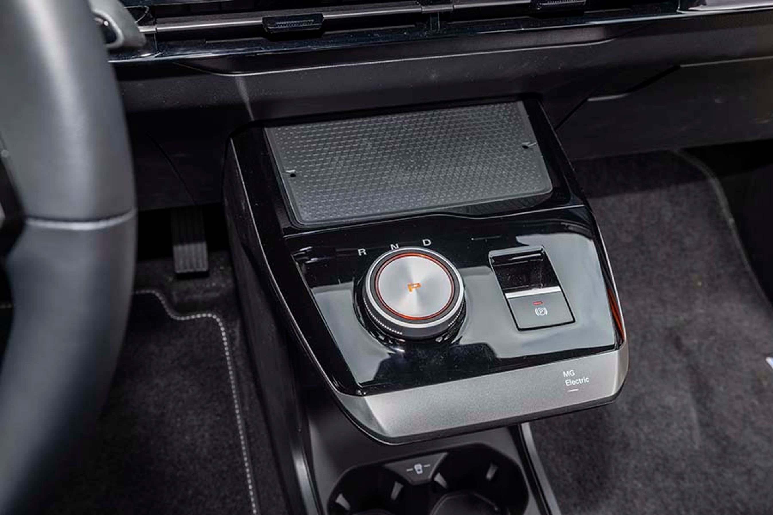 Gearvælgeren er placeret som en drejeknap på en konsol under skærmen, og den elektriske P-bremse er af den automatiske type. Foran er der trådløs opladning af mobilen.