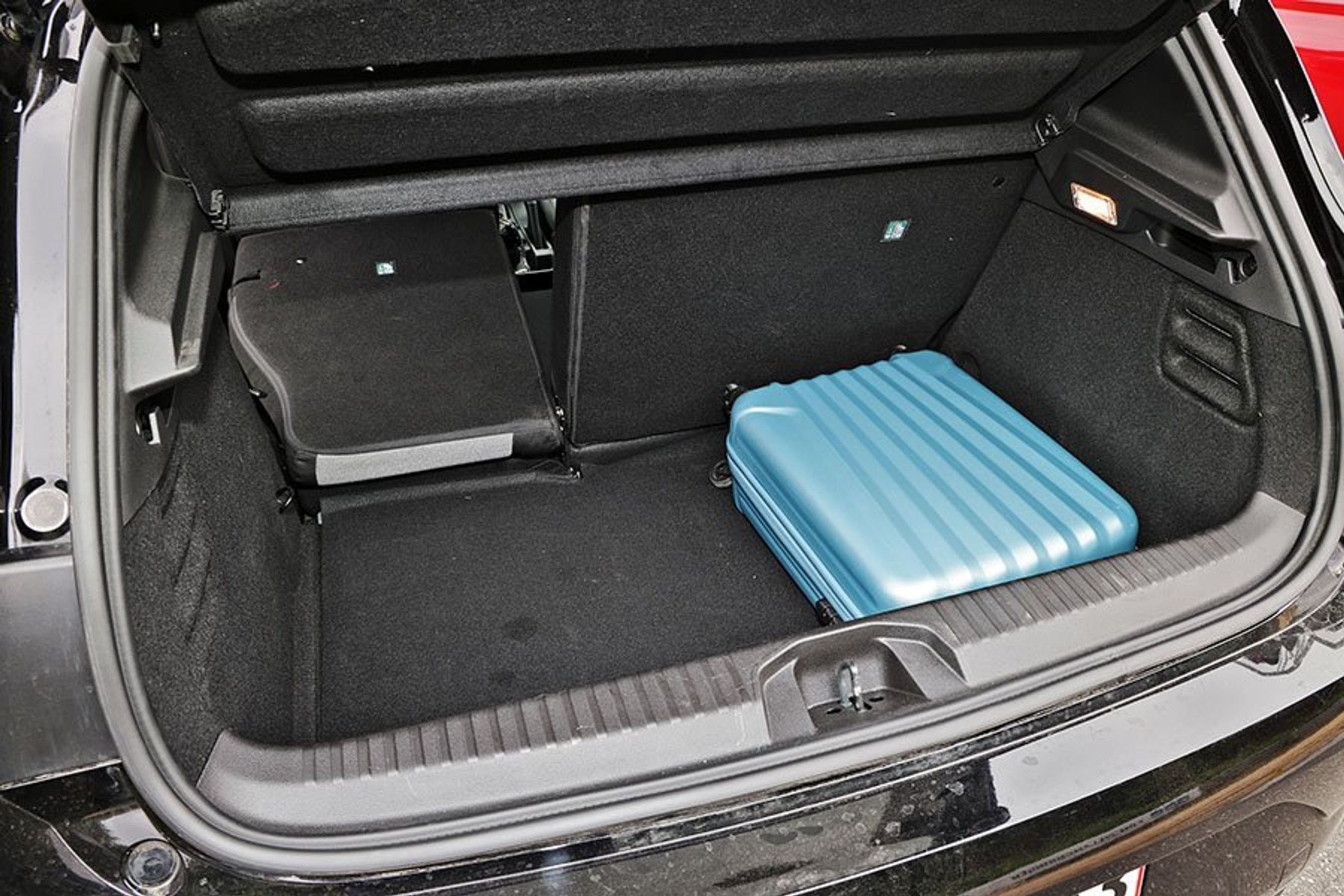 Bagagerum med blå kuffert i en Renault Clio