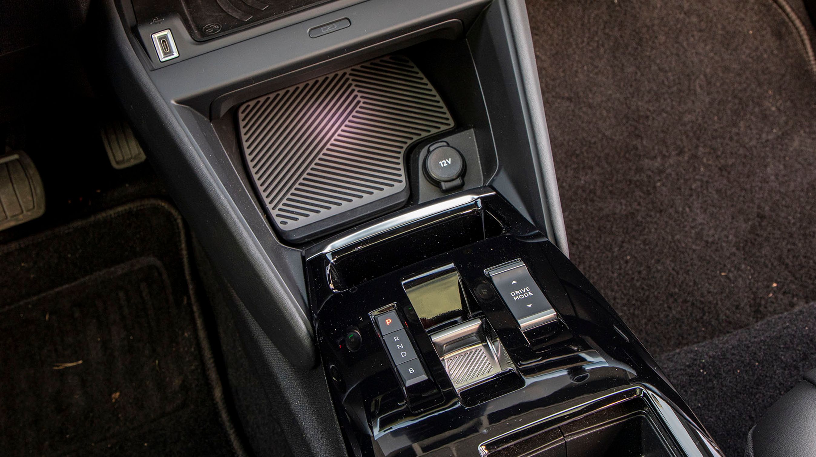 Mellem forsæderne er en meget lille gearvælger placeret sammen med knappen til styring af Drive Modes. Der er plads til en telefon med trådløs opladning lige under knapperne til varme- og ventilationsanlægget.