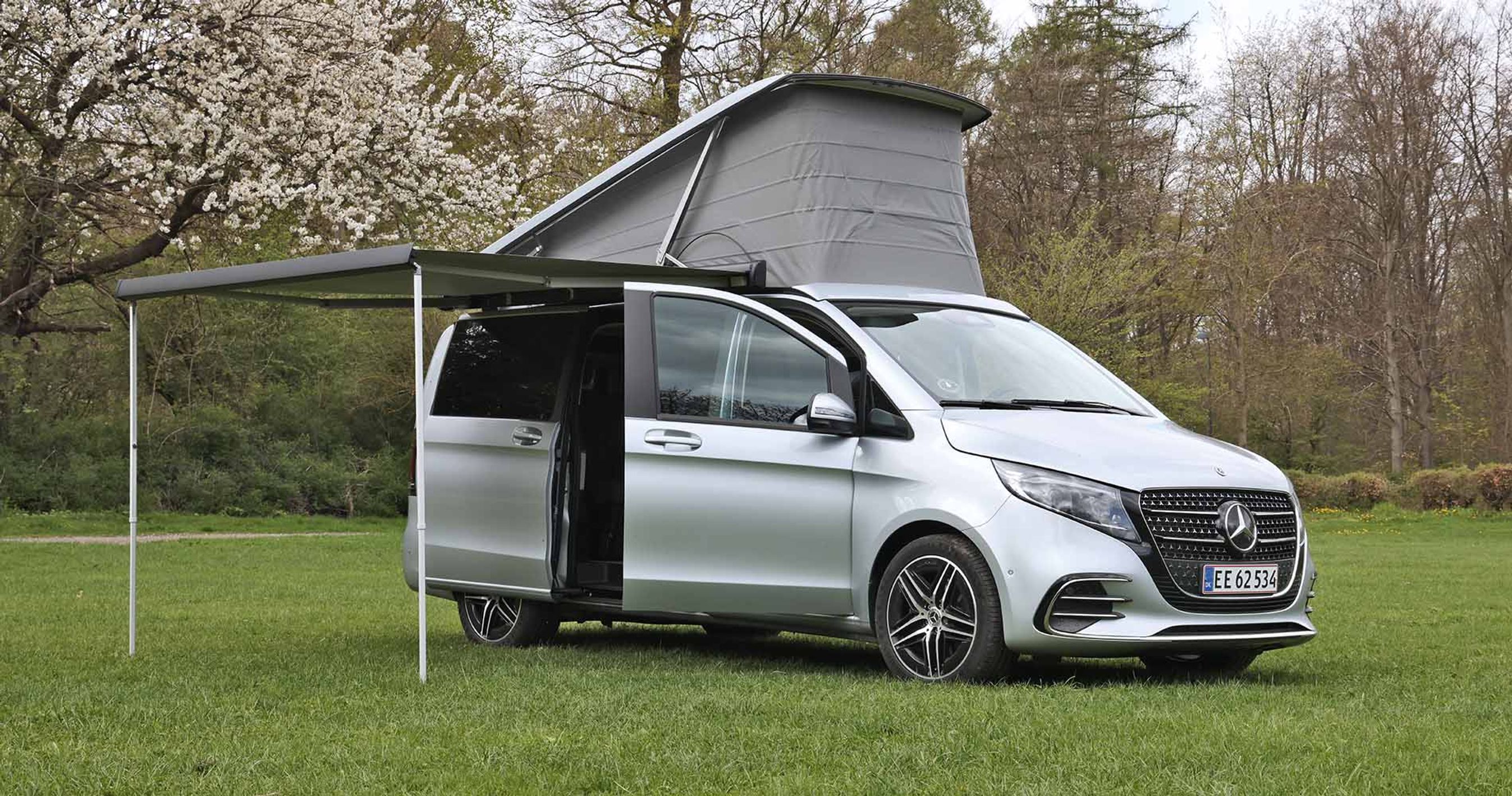 En Mercedes-Benz Marco Polo står på en græsplæne med taget slået op.