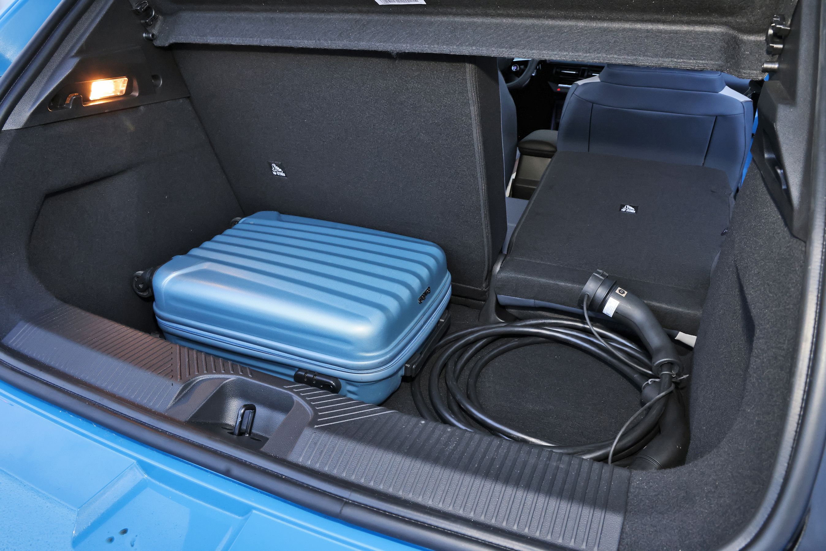 Bagagerum i en Nissan Micra med kuffert og ladekabel