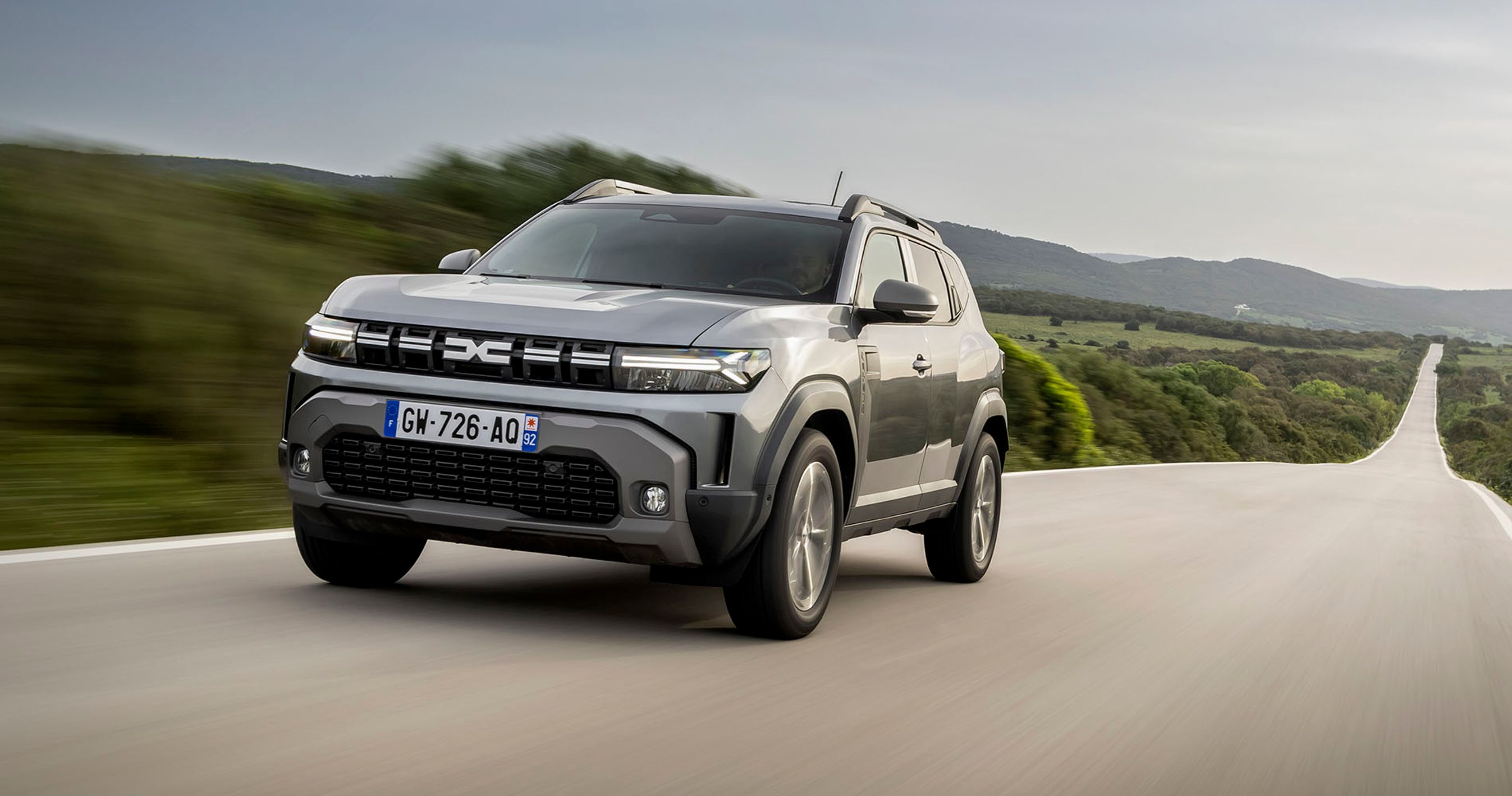 Dacia Duster set forfra kører på lang, lige landevej.