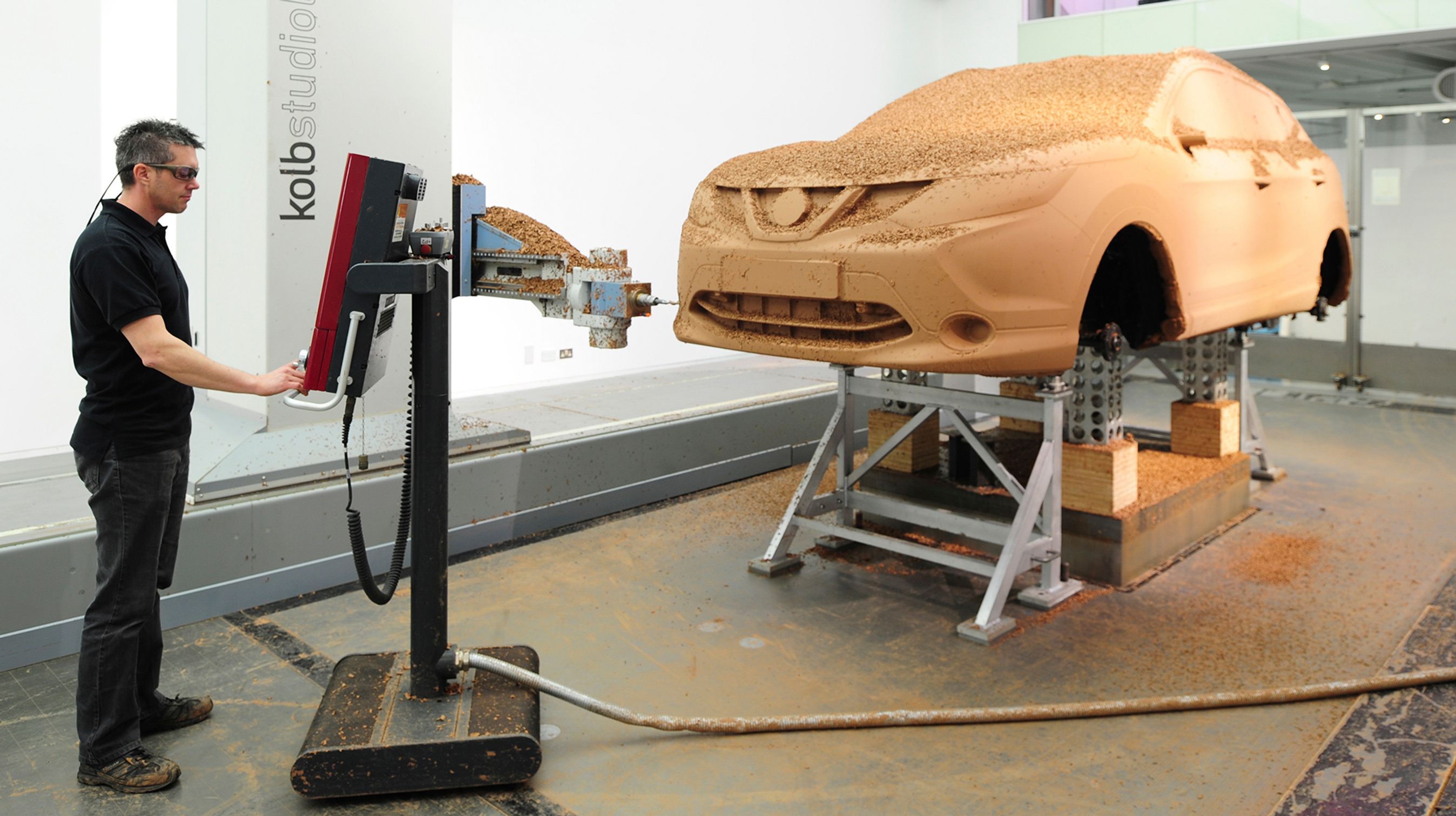 En 1:1 lermodel måles op ved hjælp af en 3D-målemaskine, der kan omsætte det håndbearbejdede design til en digital model.