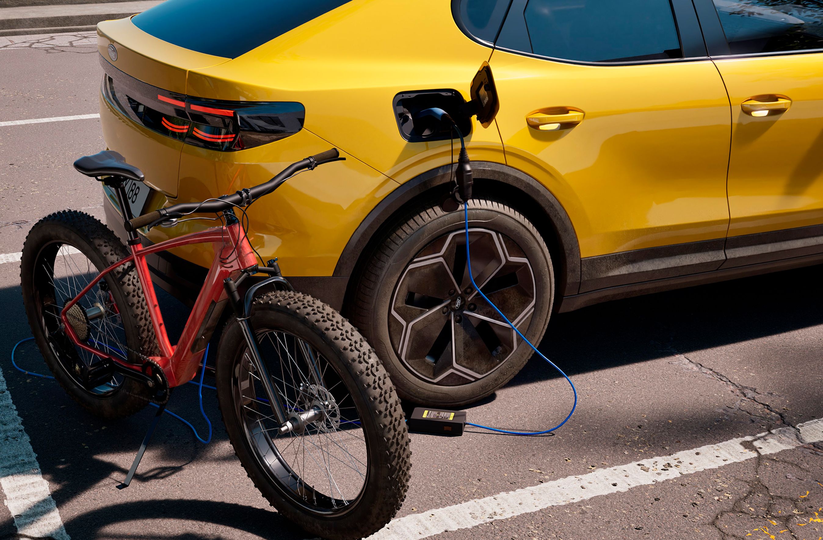 Gul Ford Capri med ladekabel tilsluttet en elcykel.