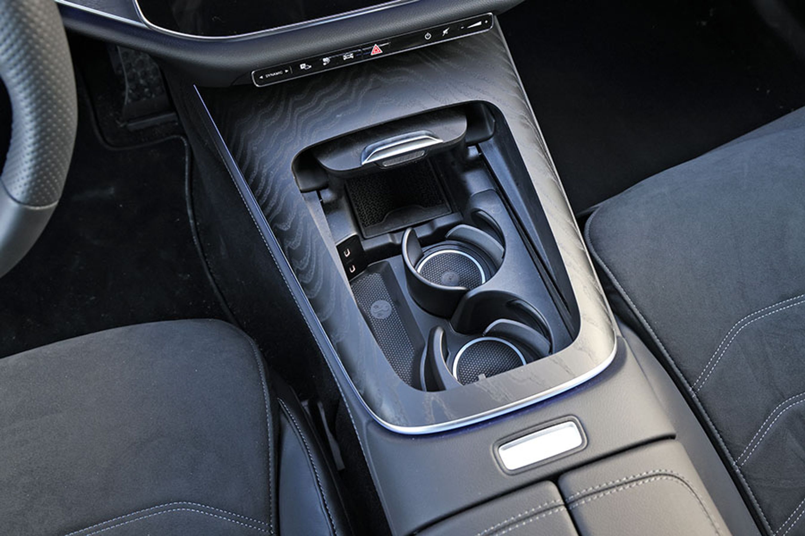 Der er fine kopholdere mellem forsæderne, og længst fremme er der plads til telefonen, der får trådløs opladning. Det er dog ikke helt let at fiske telefonen op igen, når man skal ud af bilen.