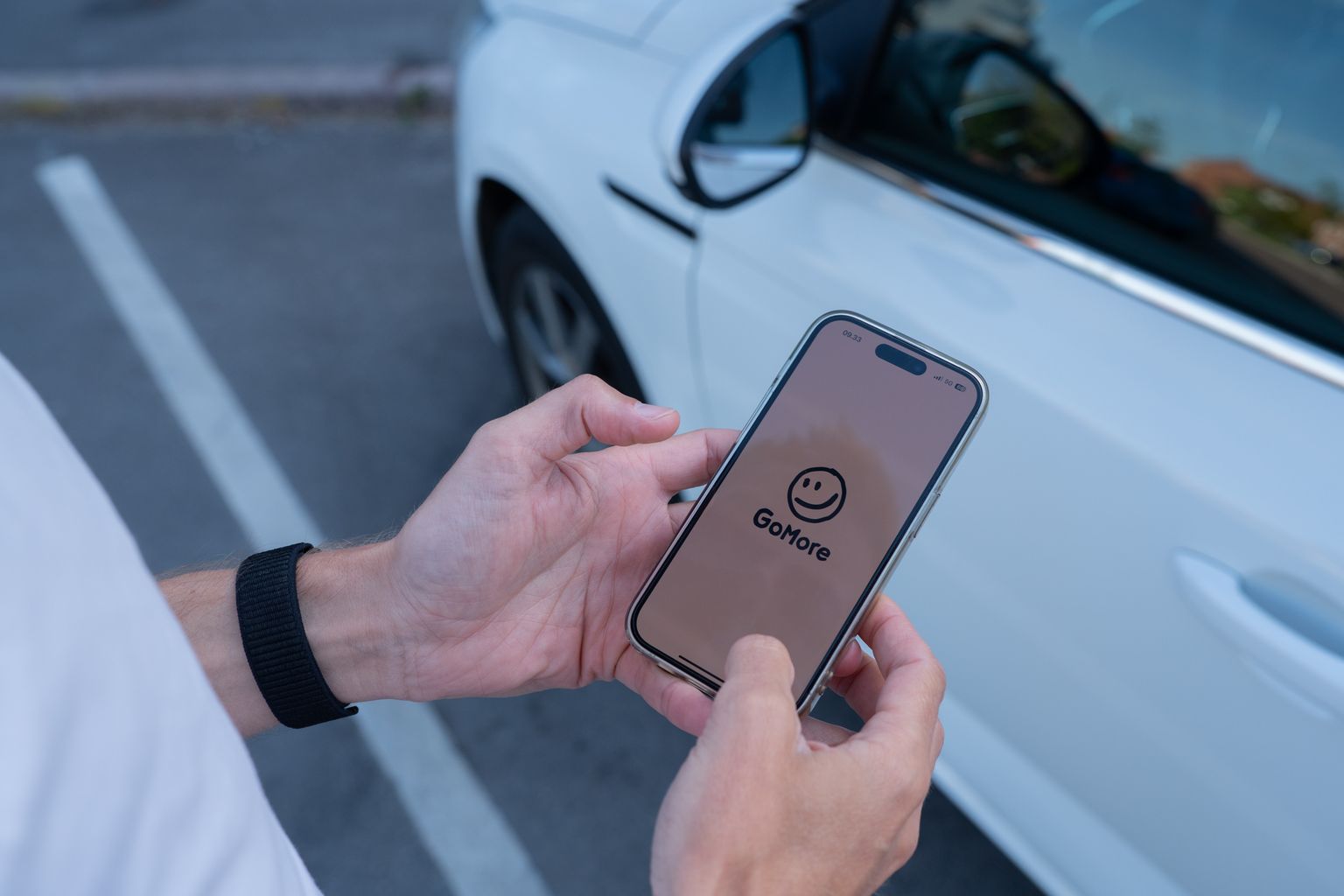 Hænder holder mobiltelefon og booker billeje via gomore app