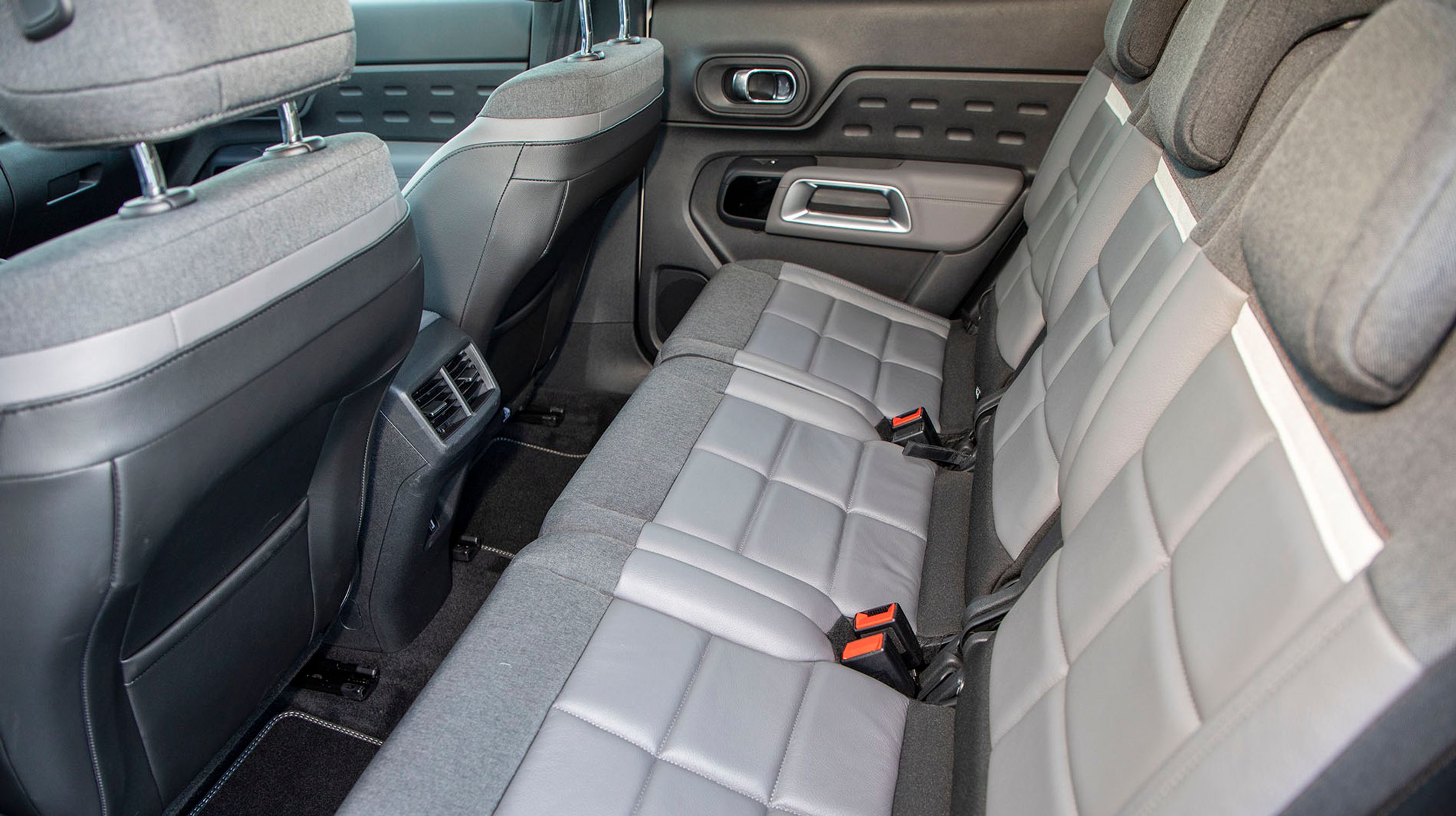 Bagsædet er opdelt i tre regulære pladser, og der er friskluftdyser mellem forsæderne. Pladsen er ikke imponerende for voksne, men det går an.