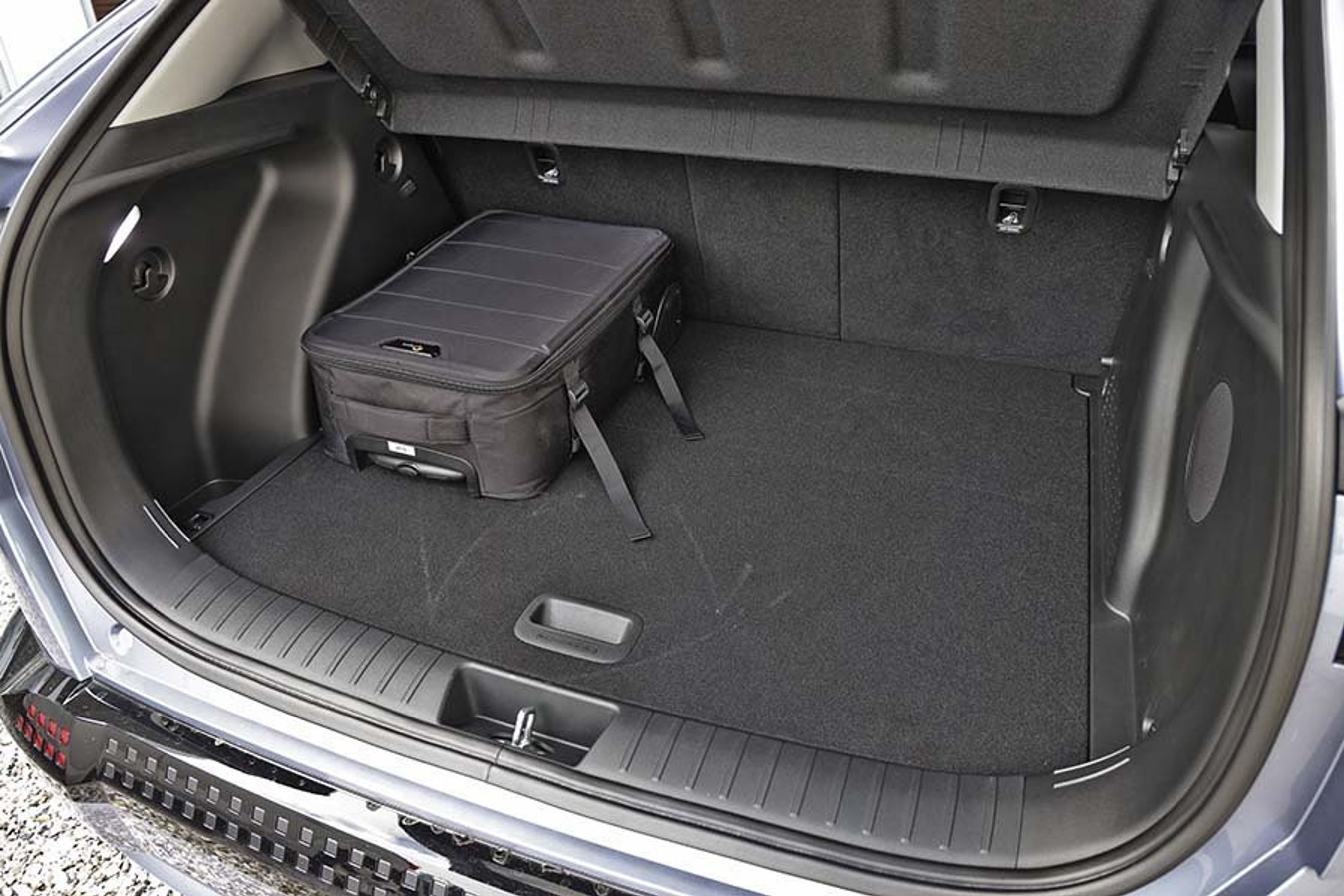 Bagagerum med sort taske i i en Hyundai Kona.