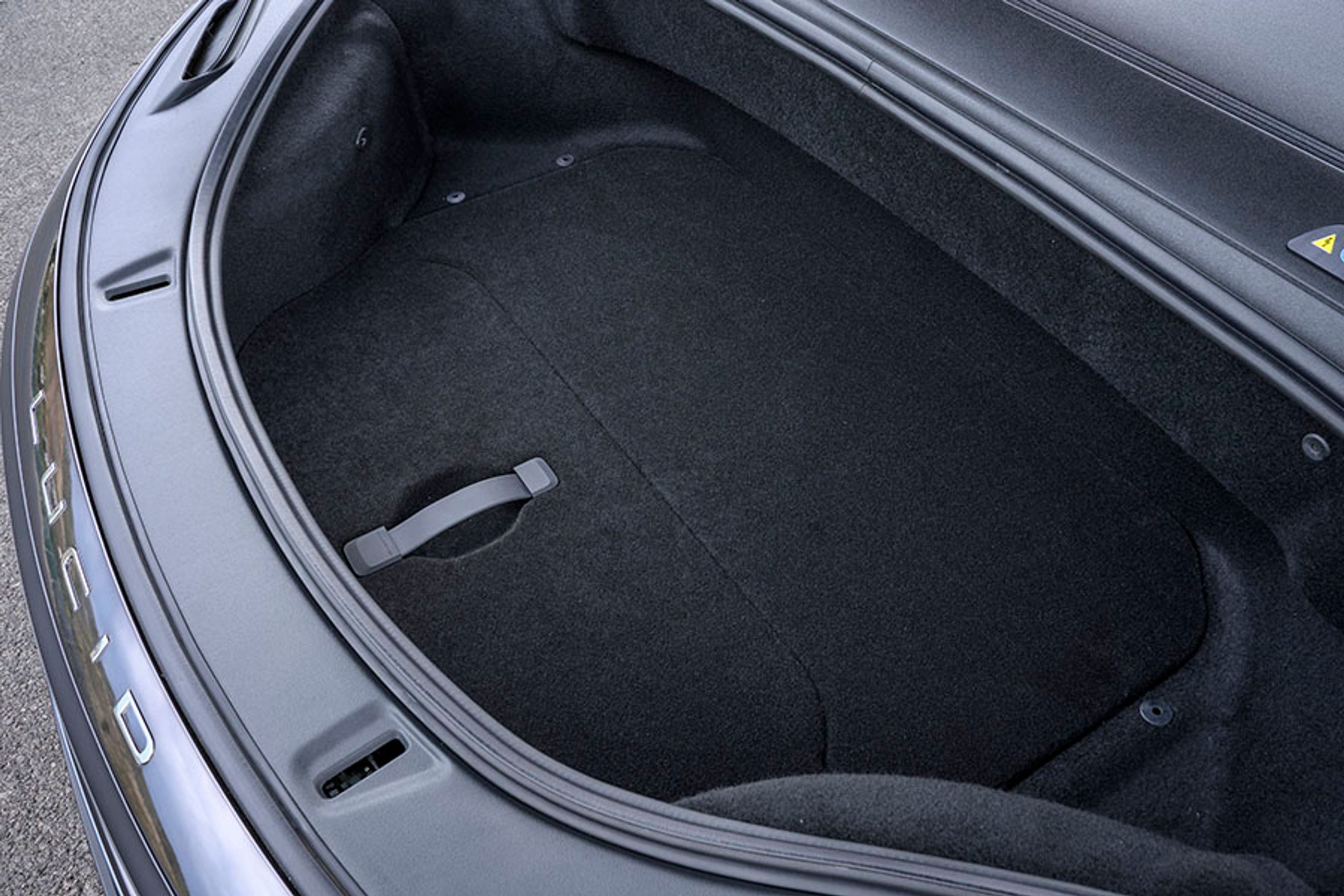 Fortil er der en gigantisk frunk (med ekstra plads under gulvet), hvor man ikke bare kan opbevare ladekabler, der er er også plads til bagage. Forklappen vipper elektrisk op.