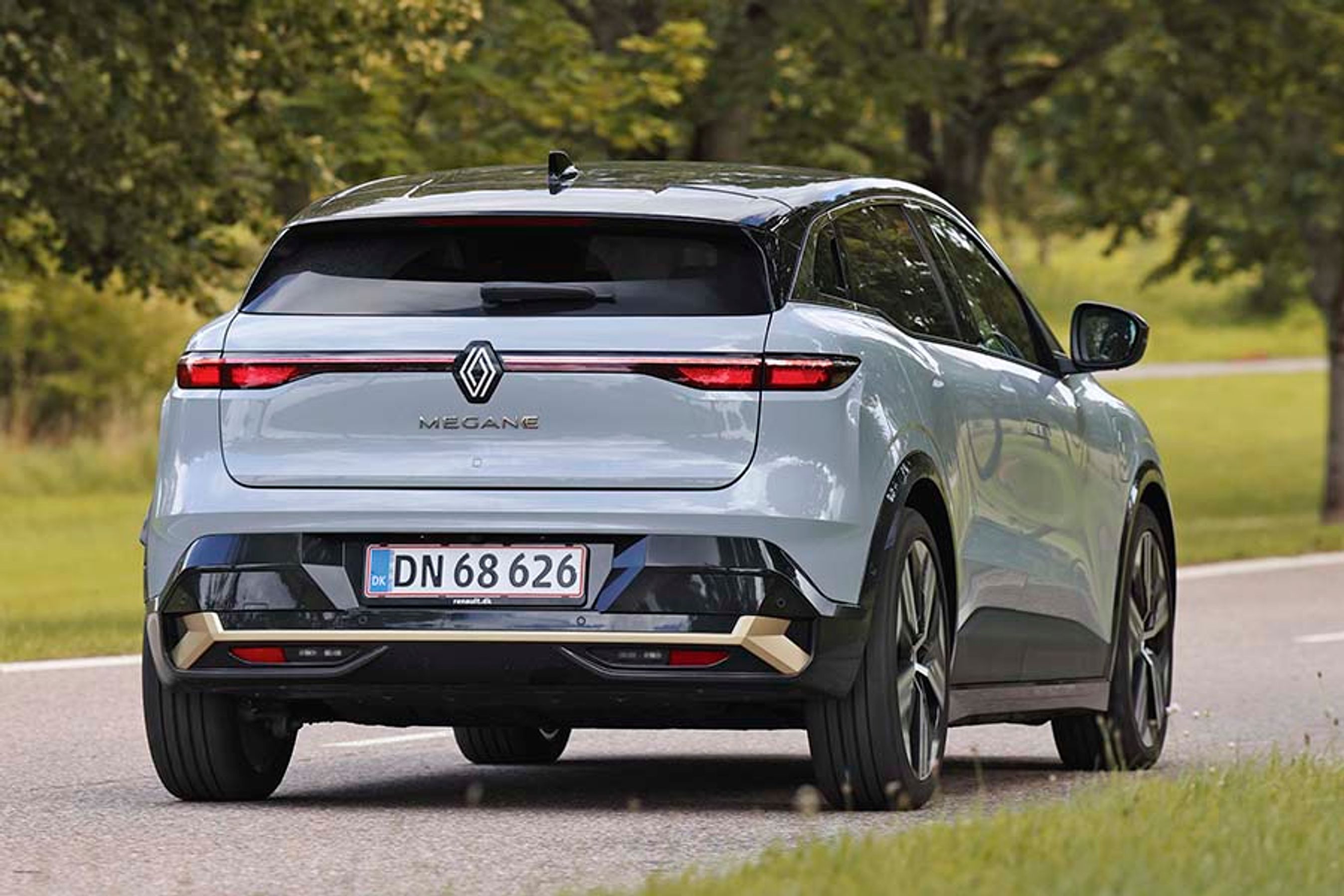 Renault Megane E-Tech st bagfra, mens den kører på landevej.