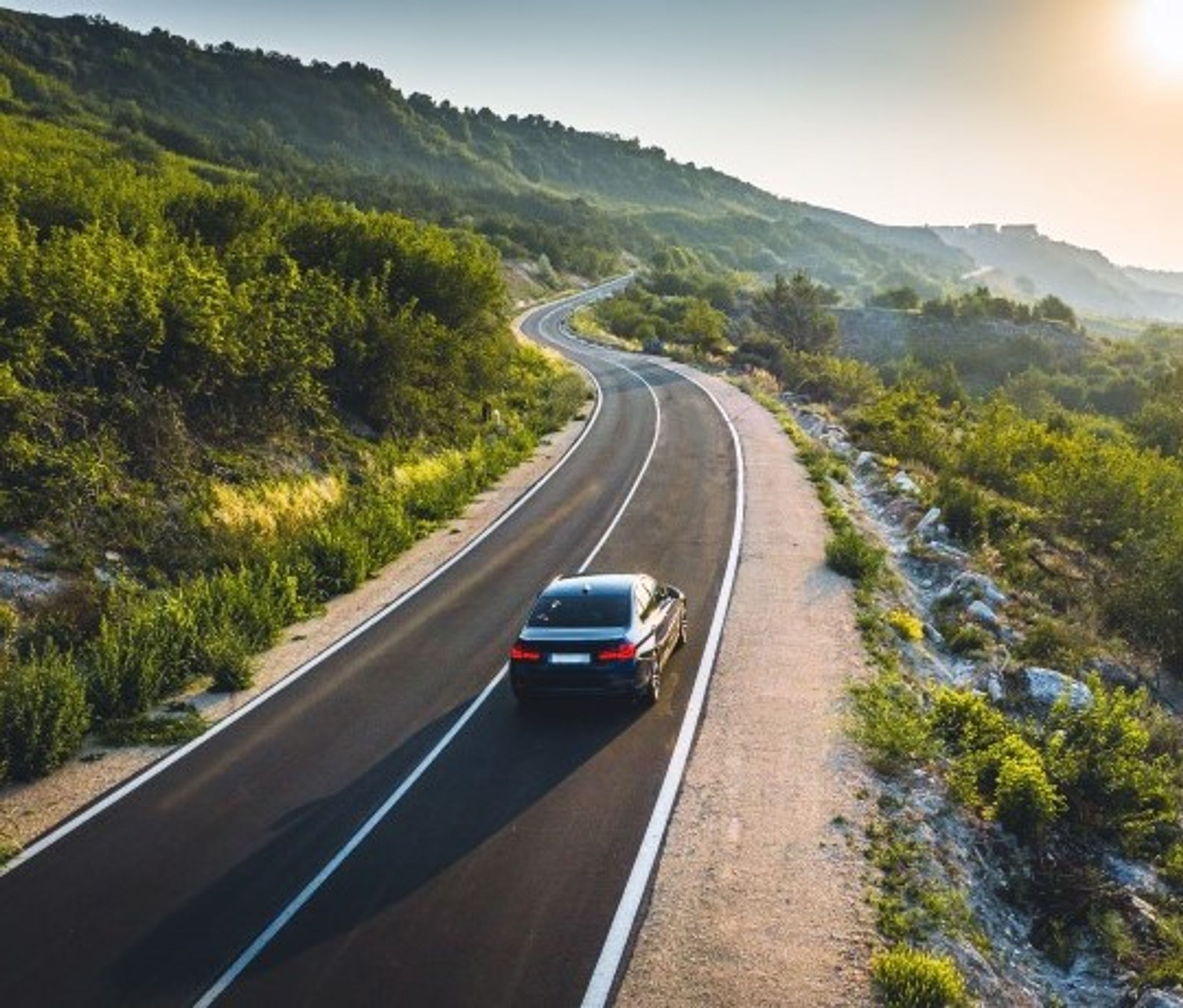 en bil kører på bilferie i bjerglandskab