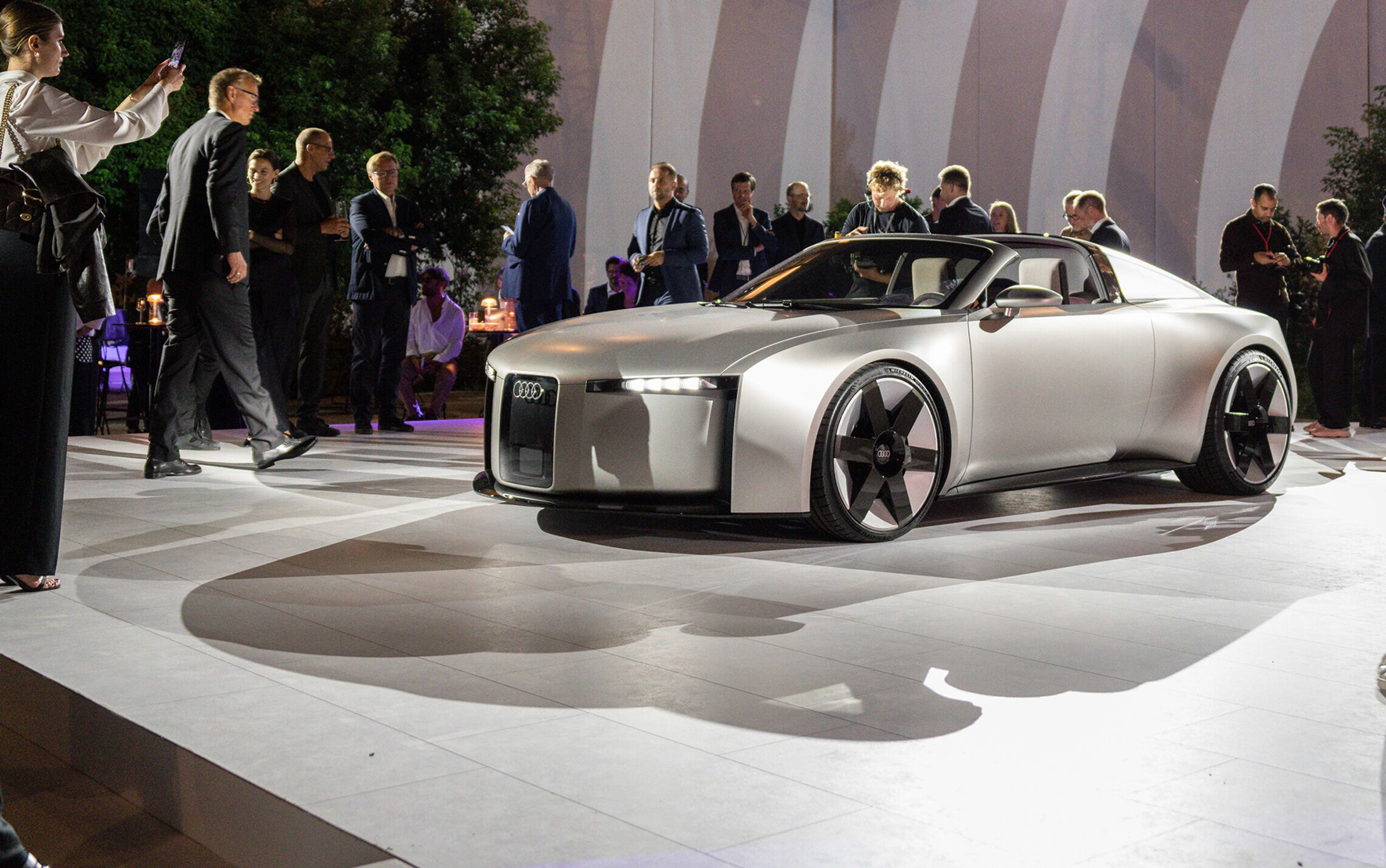 Sølvgrå konceptbil med folk rundt om.