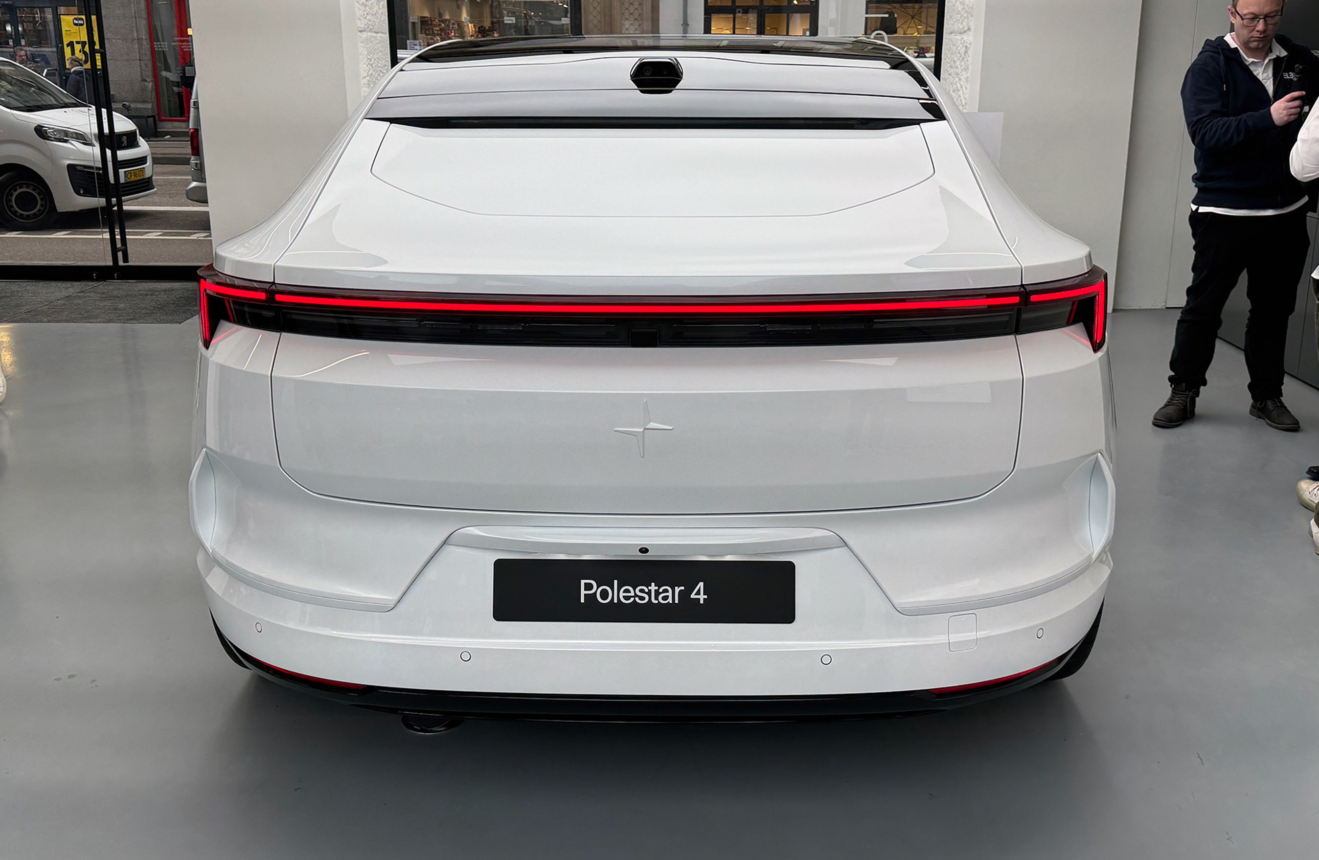 Hvid bil uden bagrude set lige bagfra