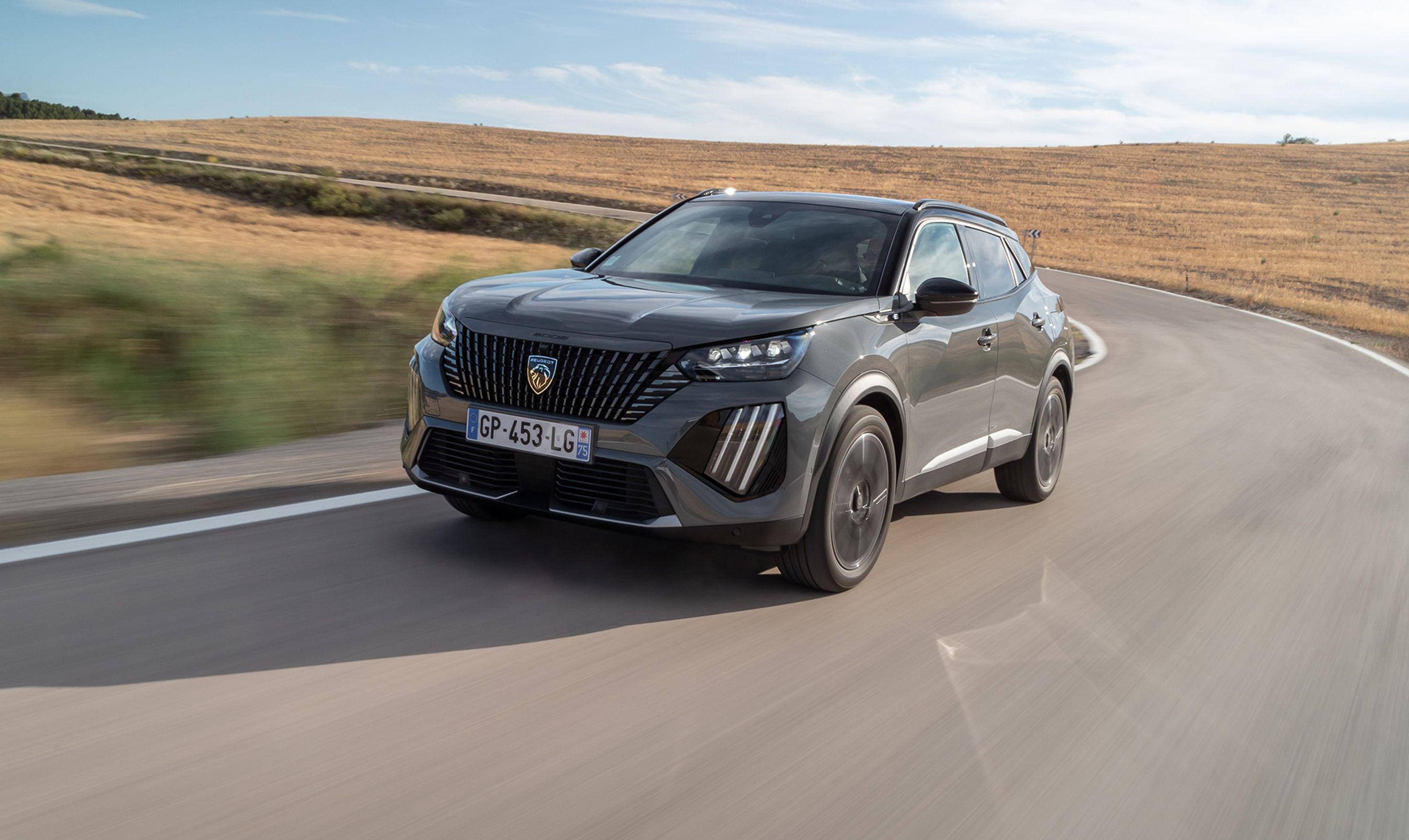 En Peugeot E-2008 kører i et sving på en landevej i høj fart